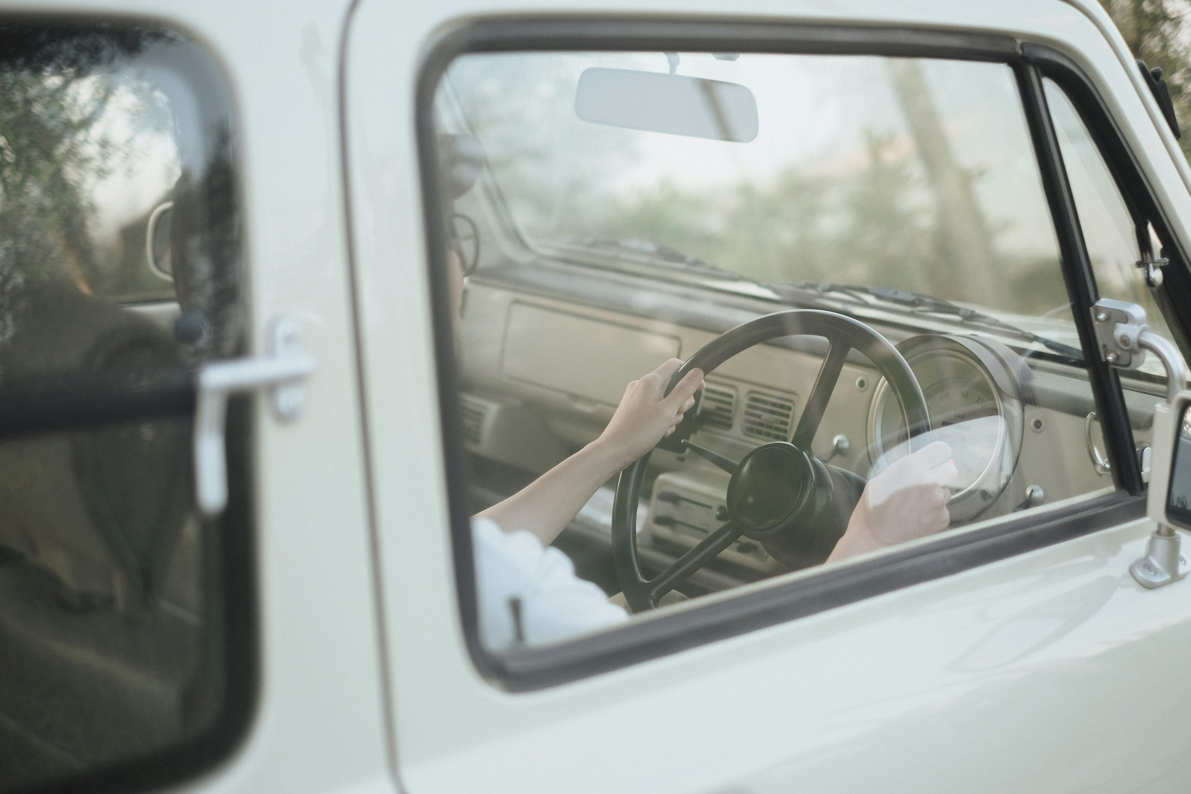 Hände am Lenkrad eines Vintage-Auto-Innenraums