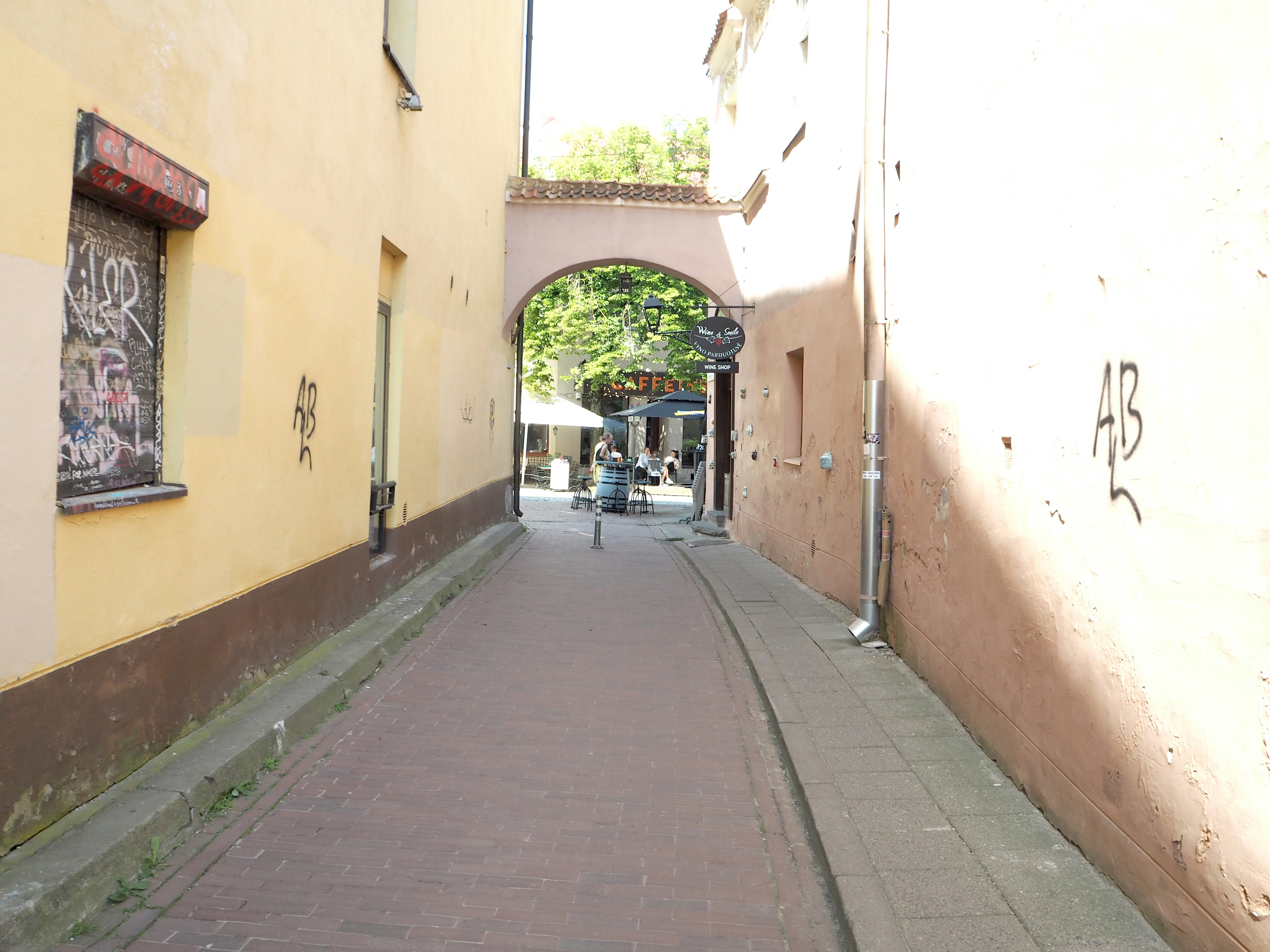 Schmale Straße mit einem Torbogen, der zu einem Platz führt