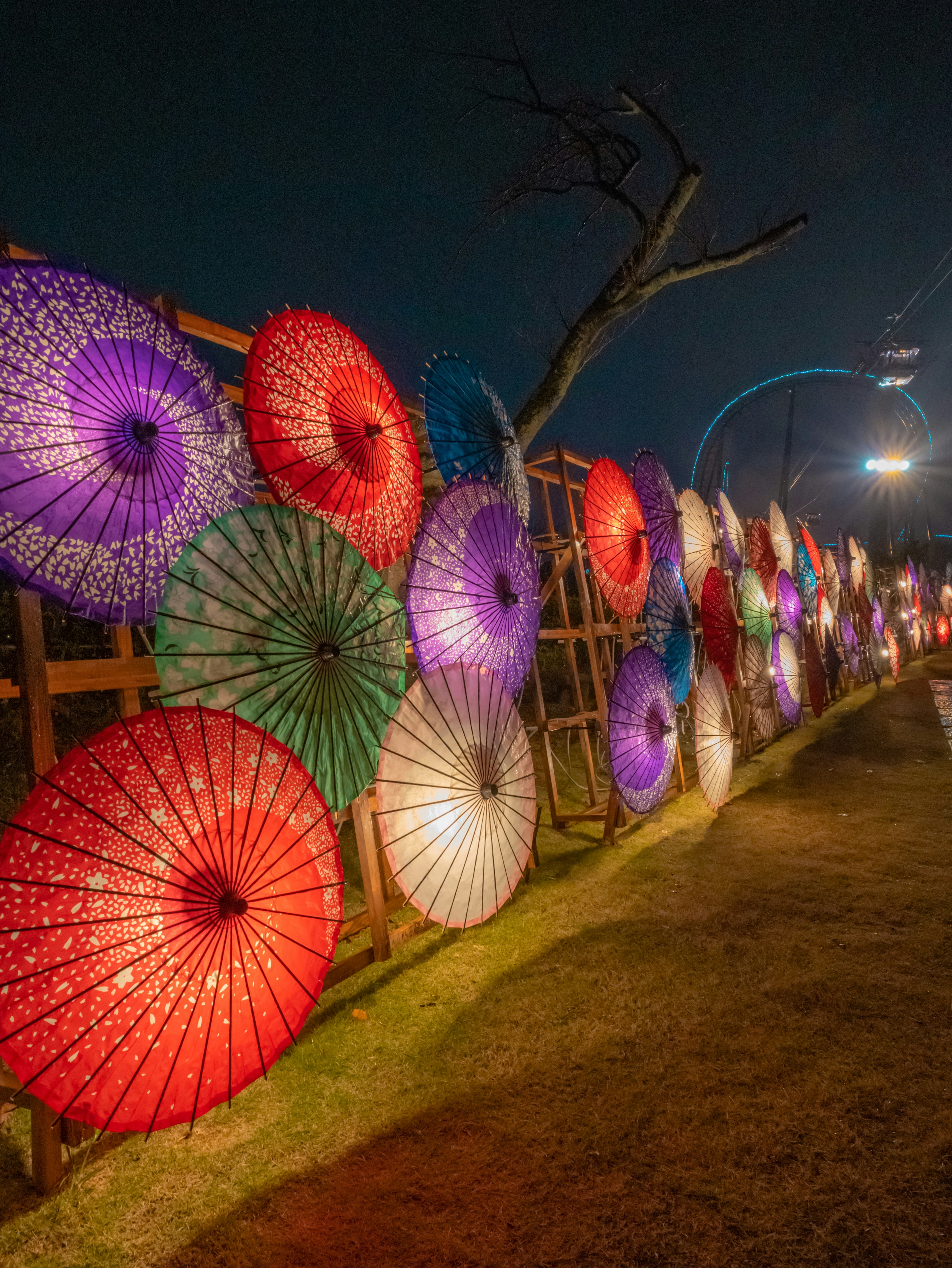 Installation artistique de parapluies colorés illuminée la nuit