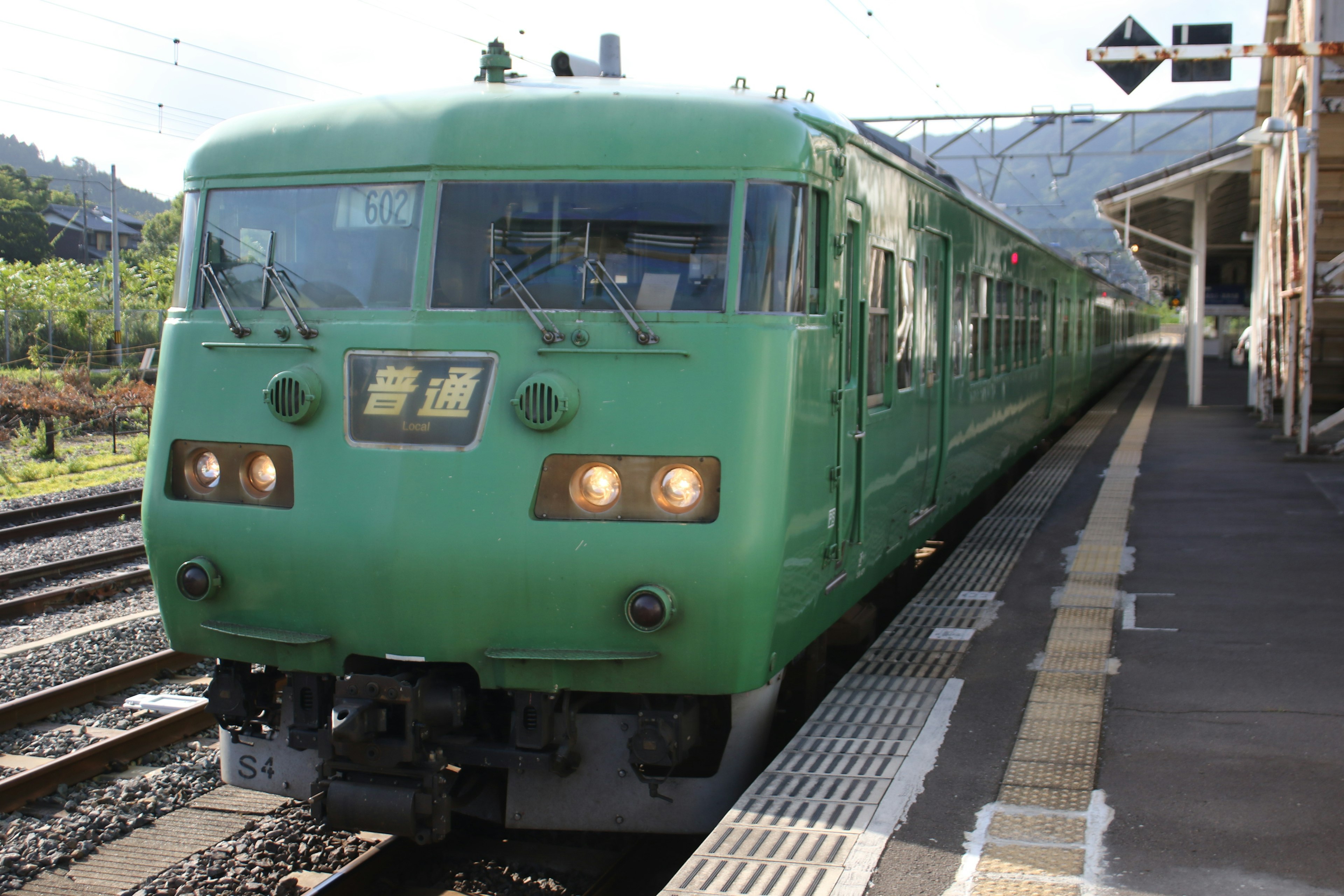 緑の列車が駅に停車している風景