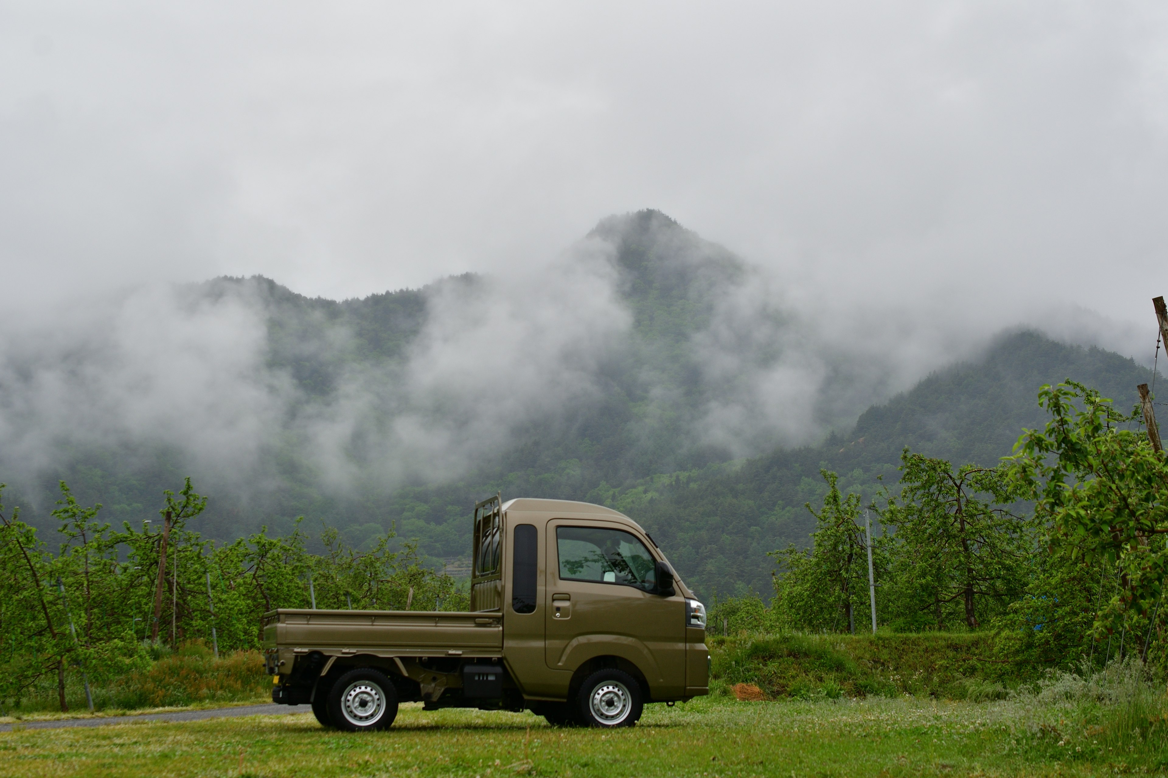 Camion marron entouré de montagnes brumeuses