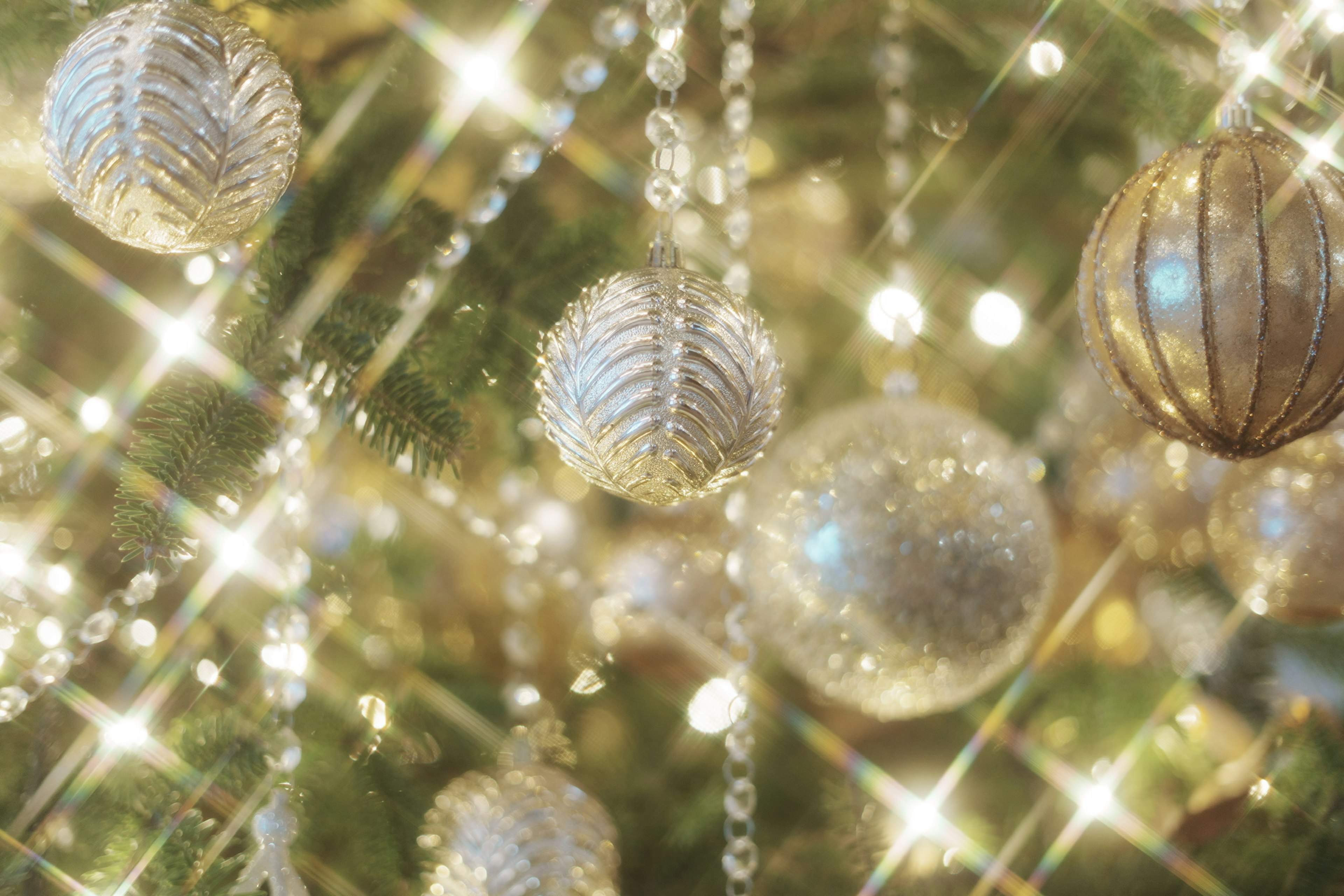 Christmas tree decorations with shining silver ornaments and light reflections