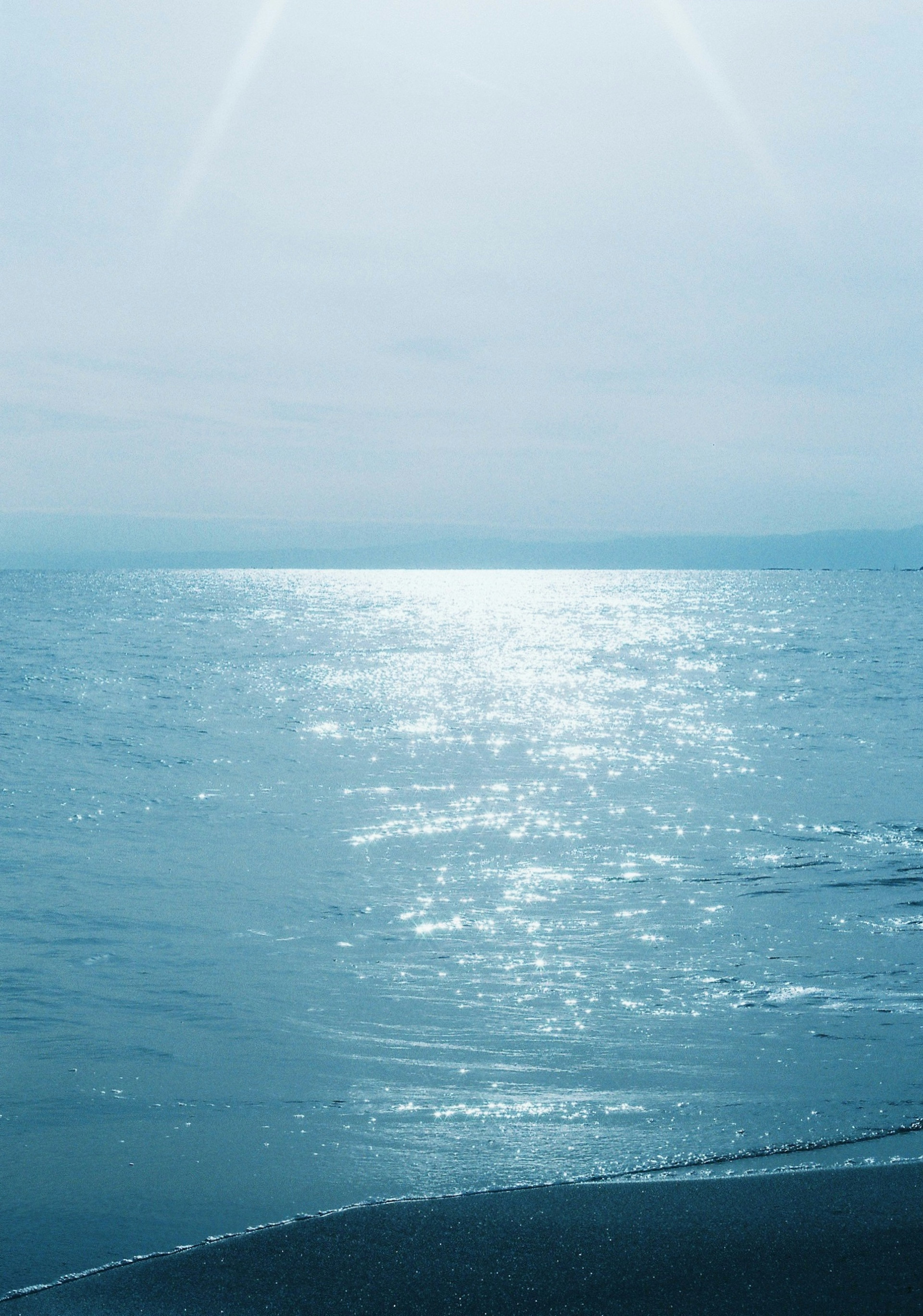 穏やかな海と反射する光のある青い水面の風景