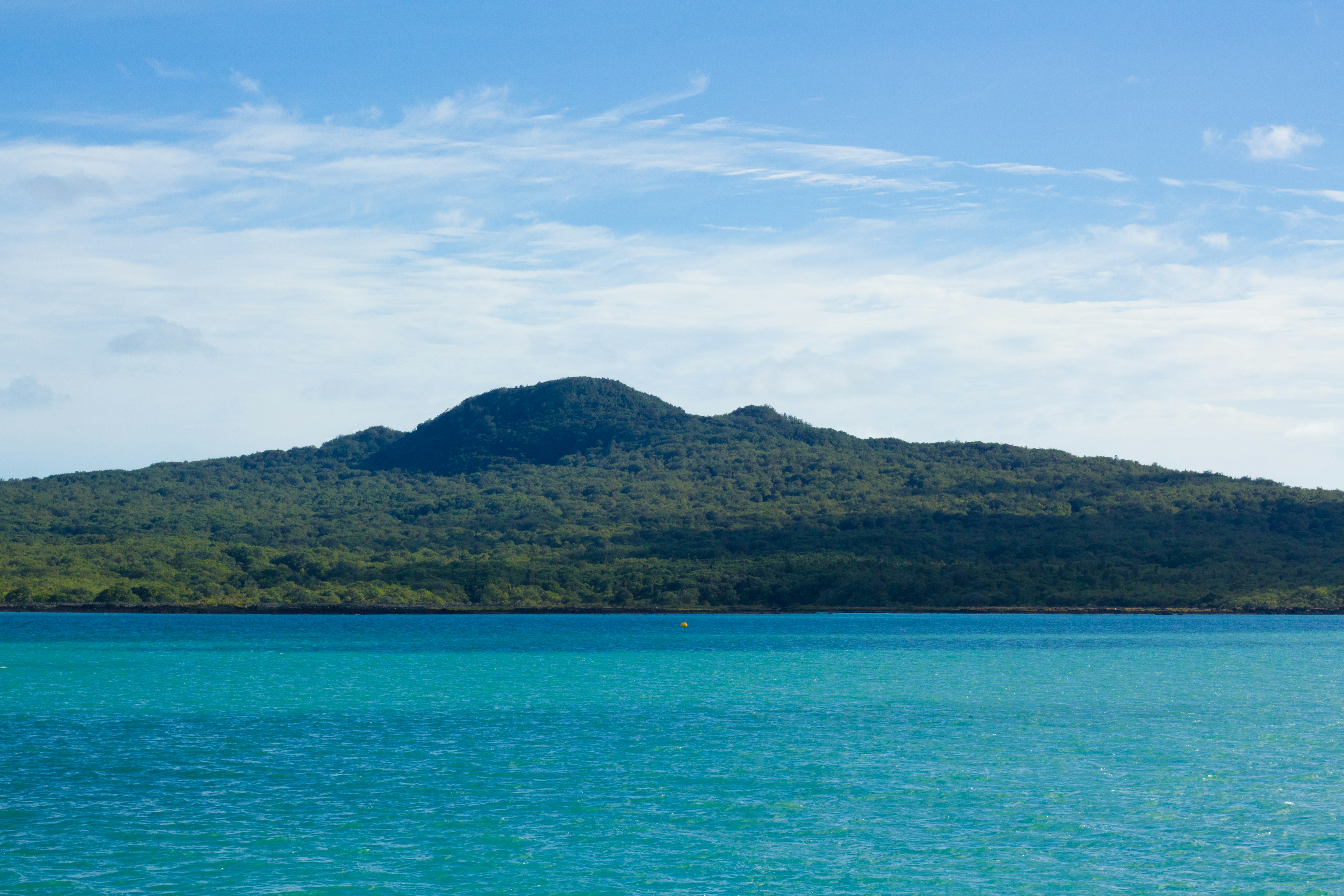 Pemandangan laut turquoise dan bukit hijau