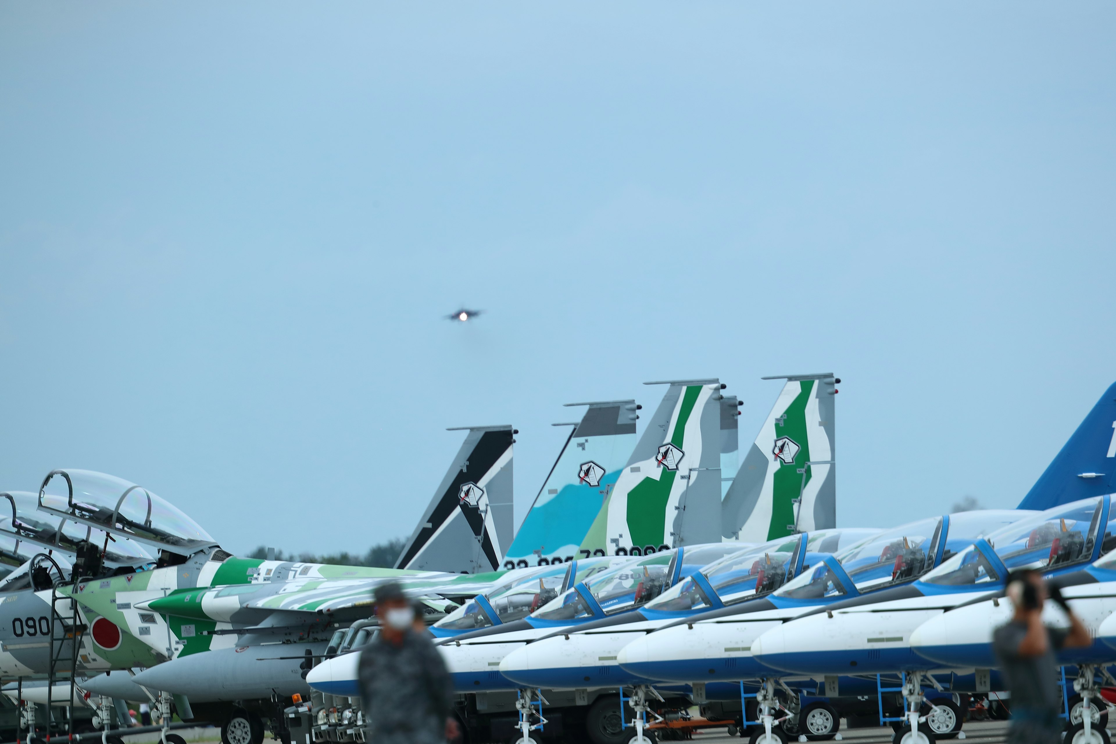 Colorful aircraft tails lined up at an airport with a clear sky