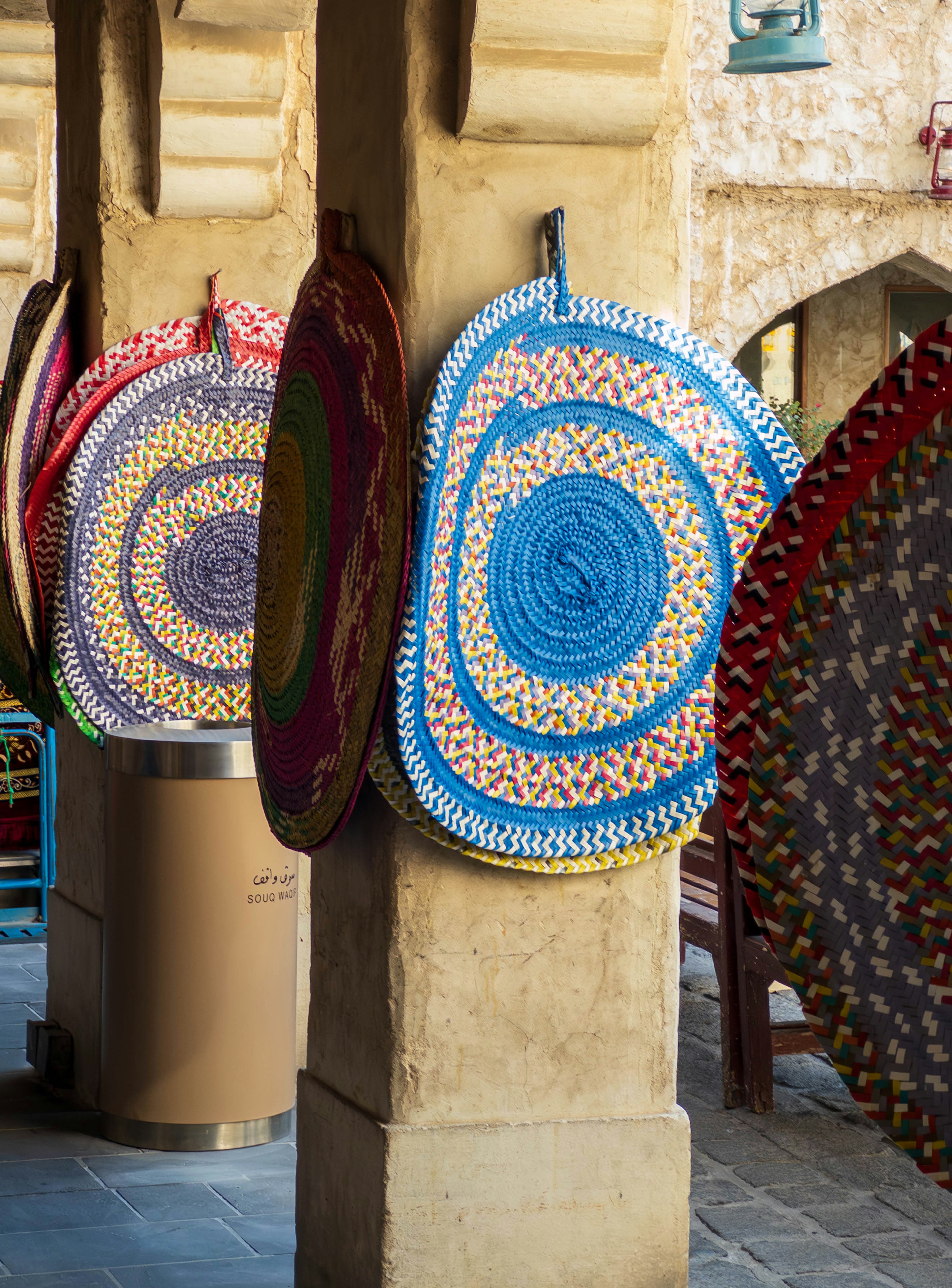 Colorful decorative mats hanging from columns