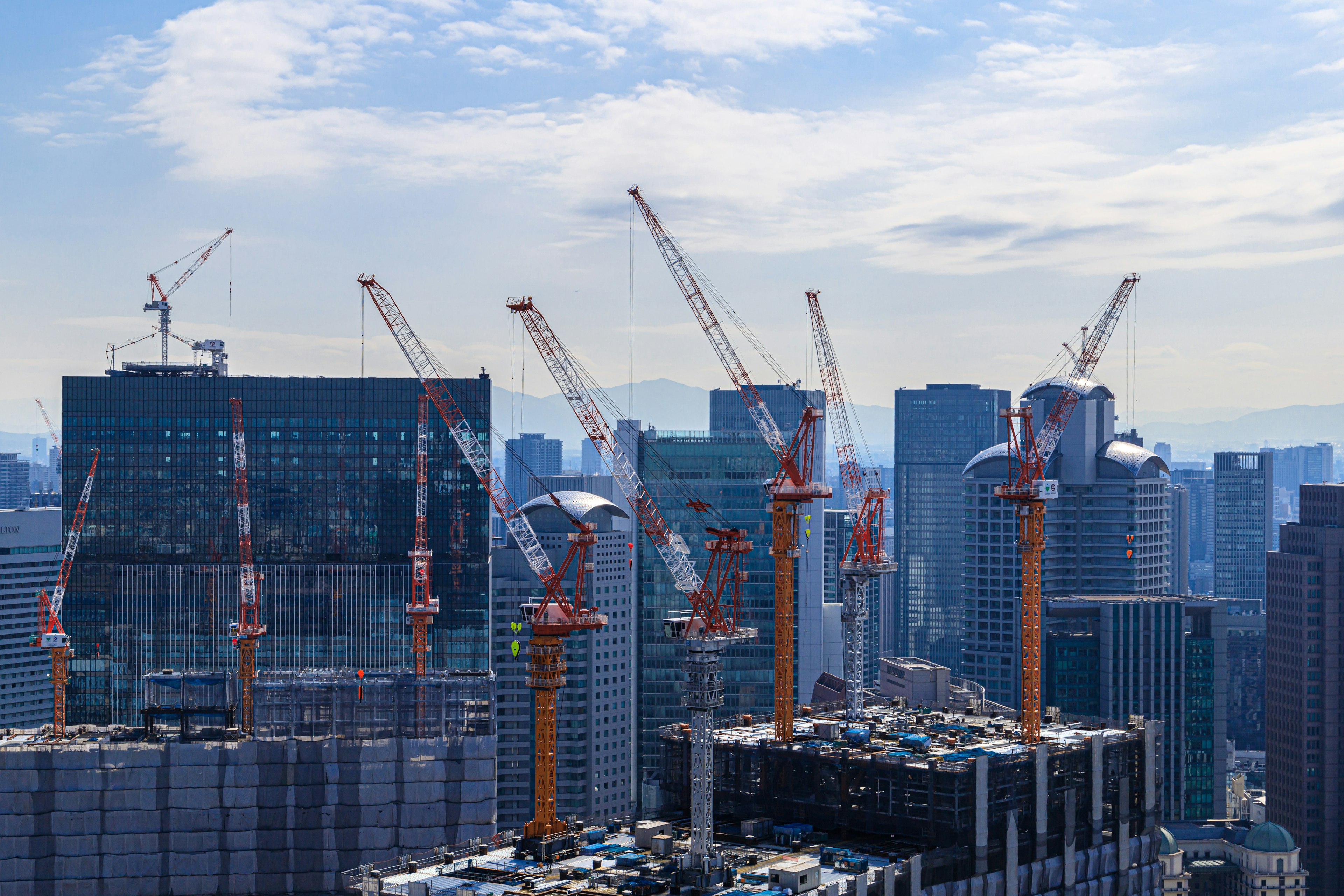 Construction site with cranes and urban skyline