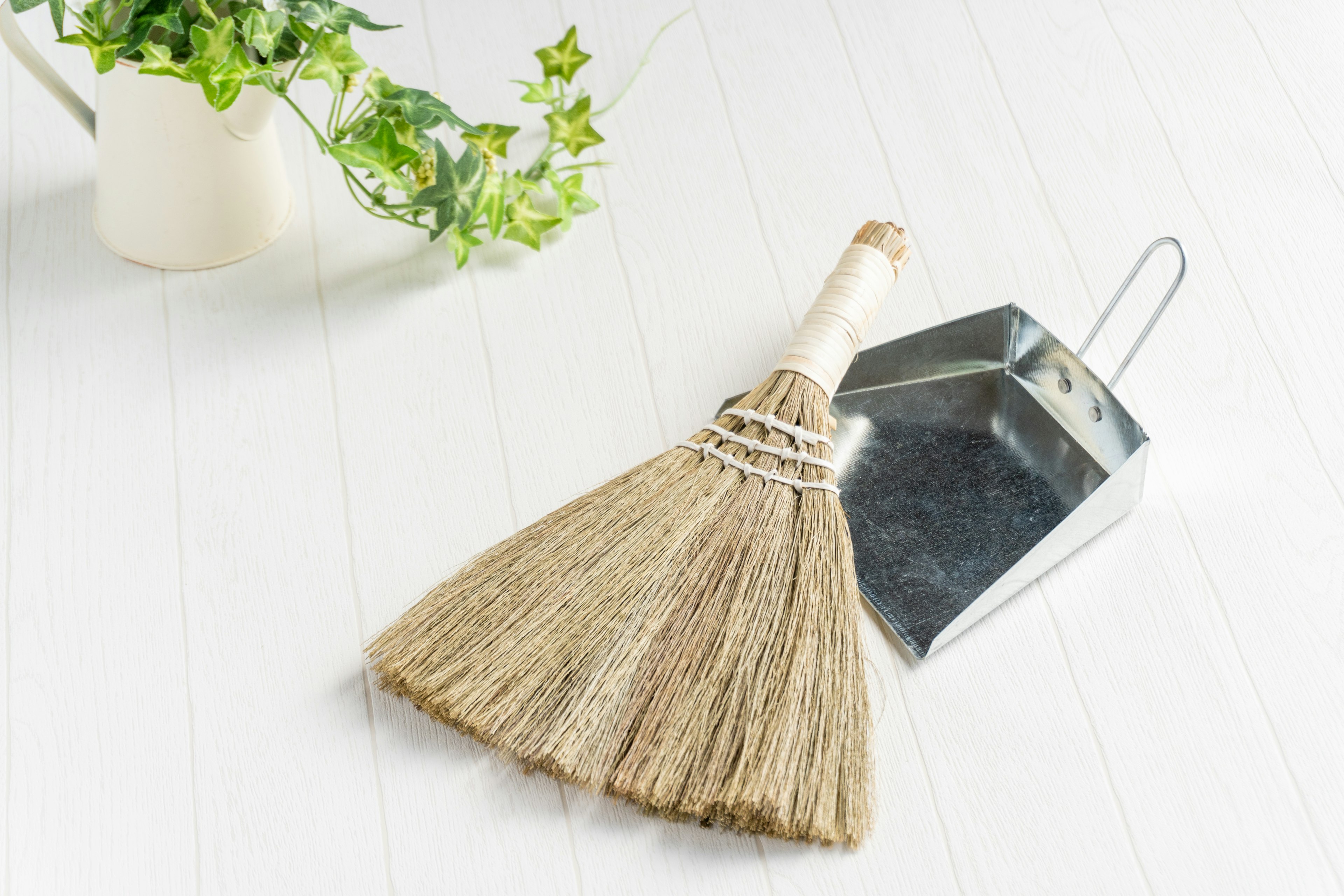 Image of a broom and dustpan arranged together on a clean surface