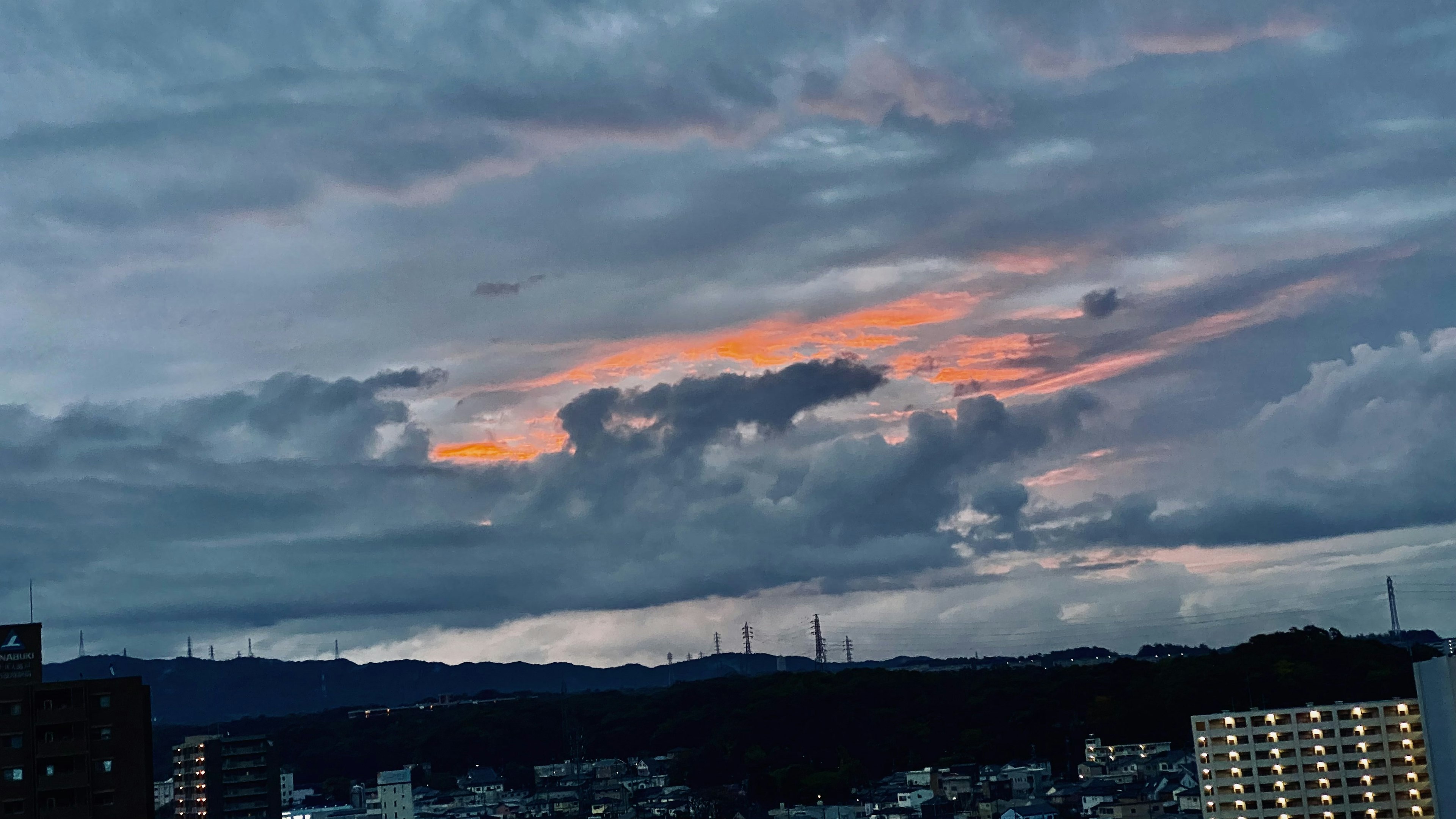 城市天際線上橙色雲彩的生動日落