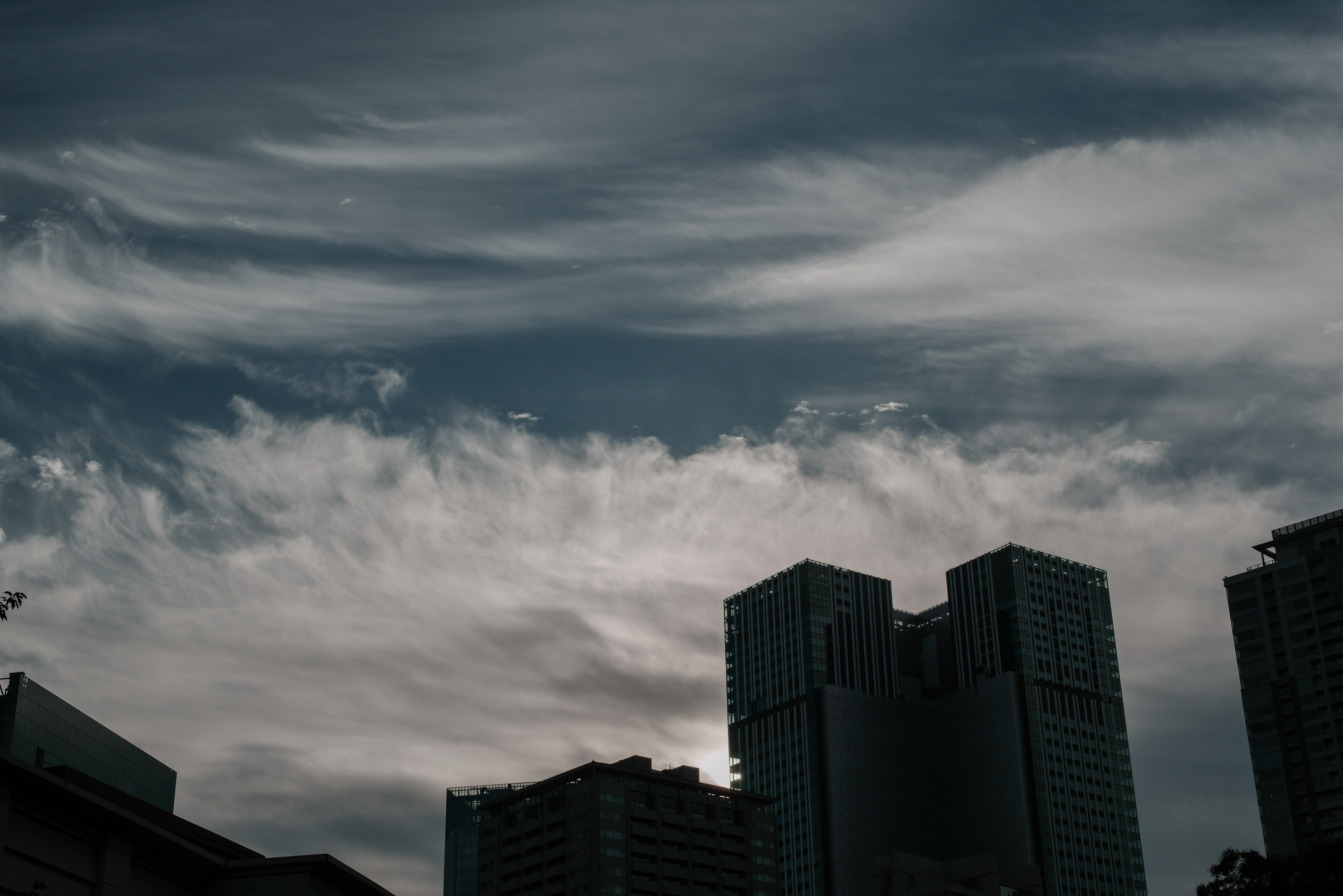 Silueta de rascacielos contra un cielo sombrío con nubes oscuras