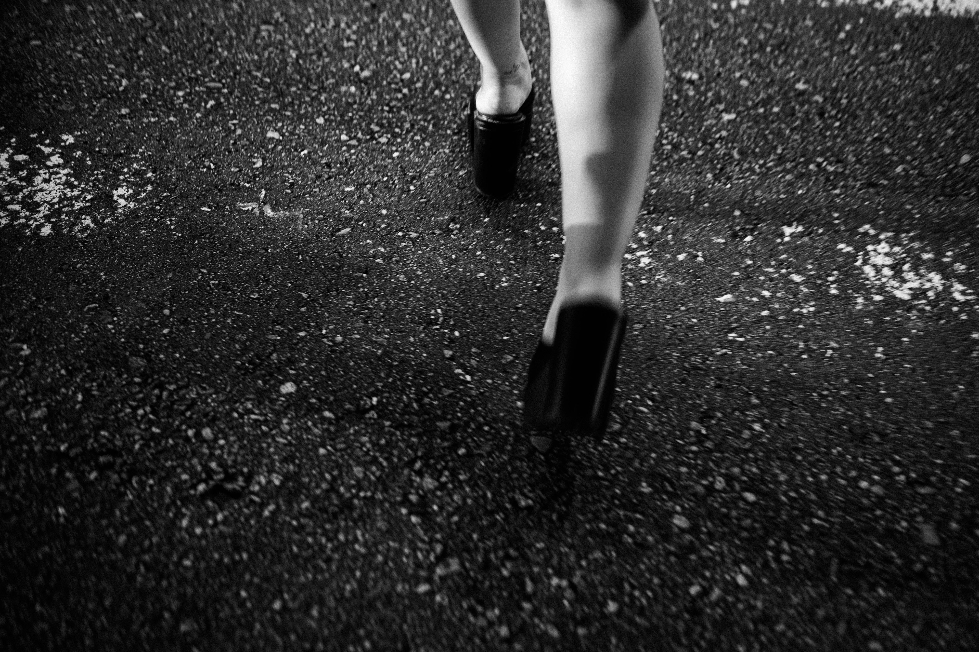 Black shoes walking on a textured surface monochrome photo