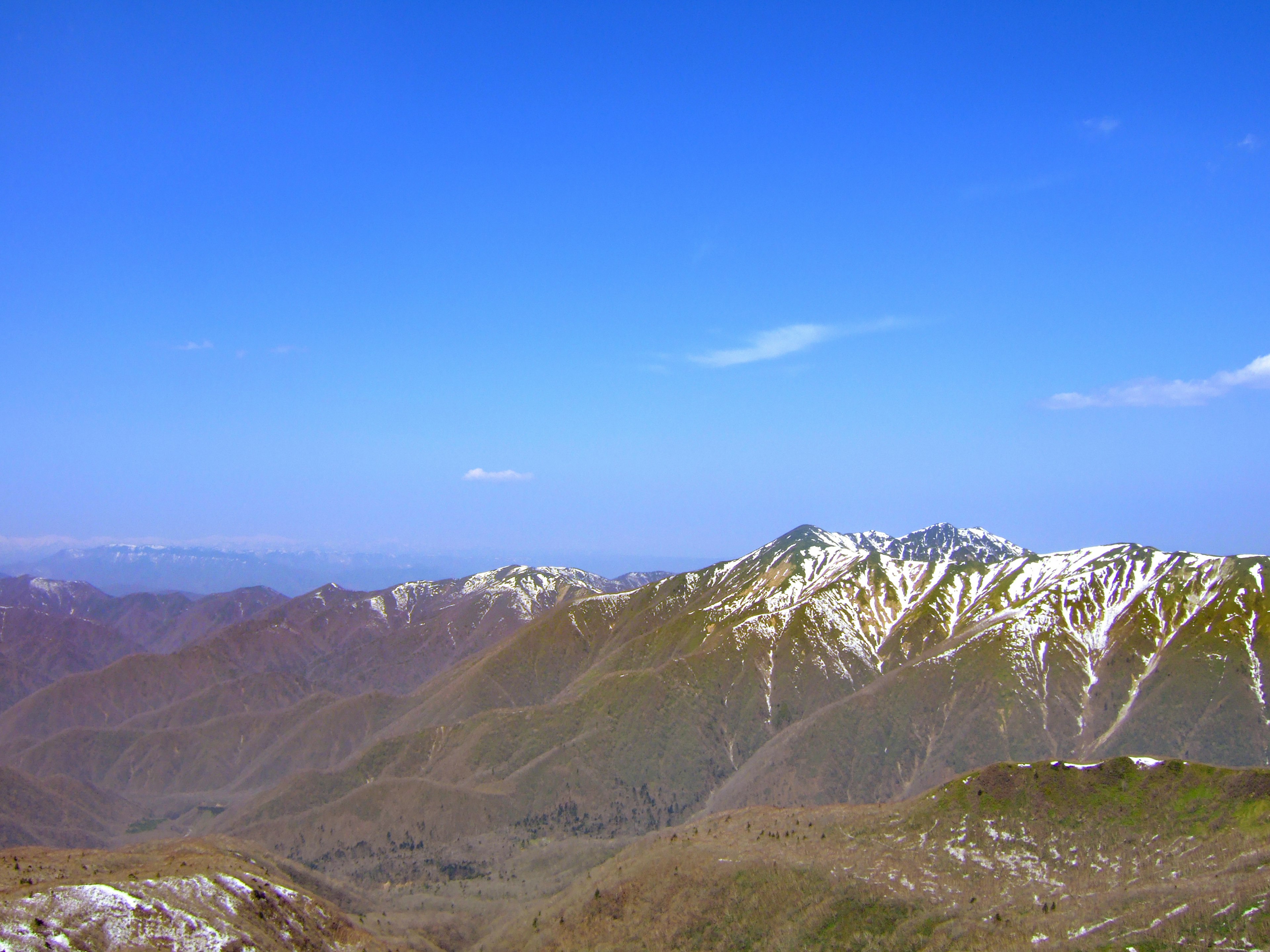 Vista escénica de montañas nevadas bajo un cielo azul claro