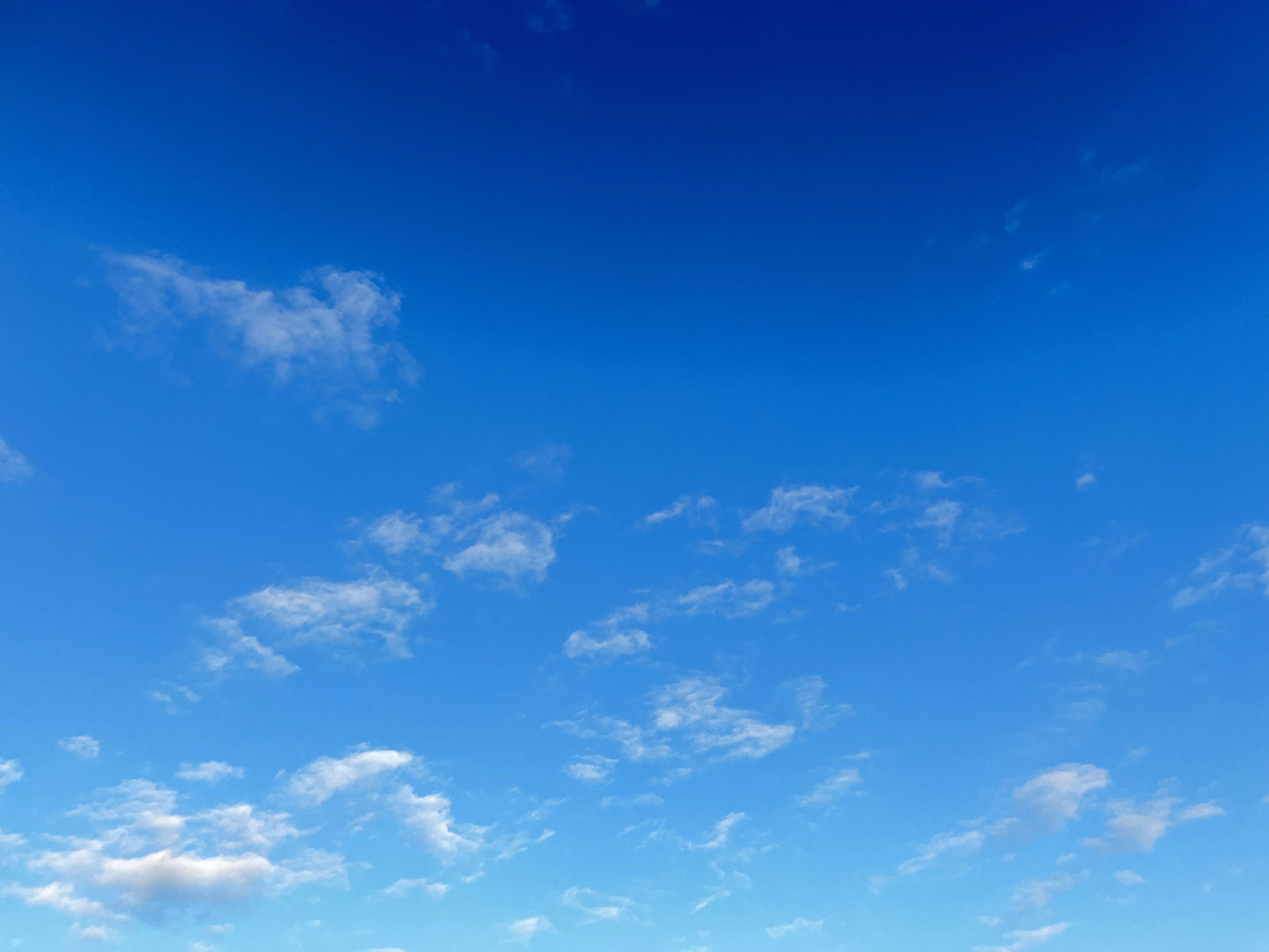 Clear blue sky with scattered white clouds