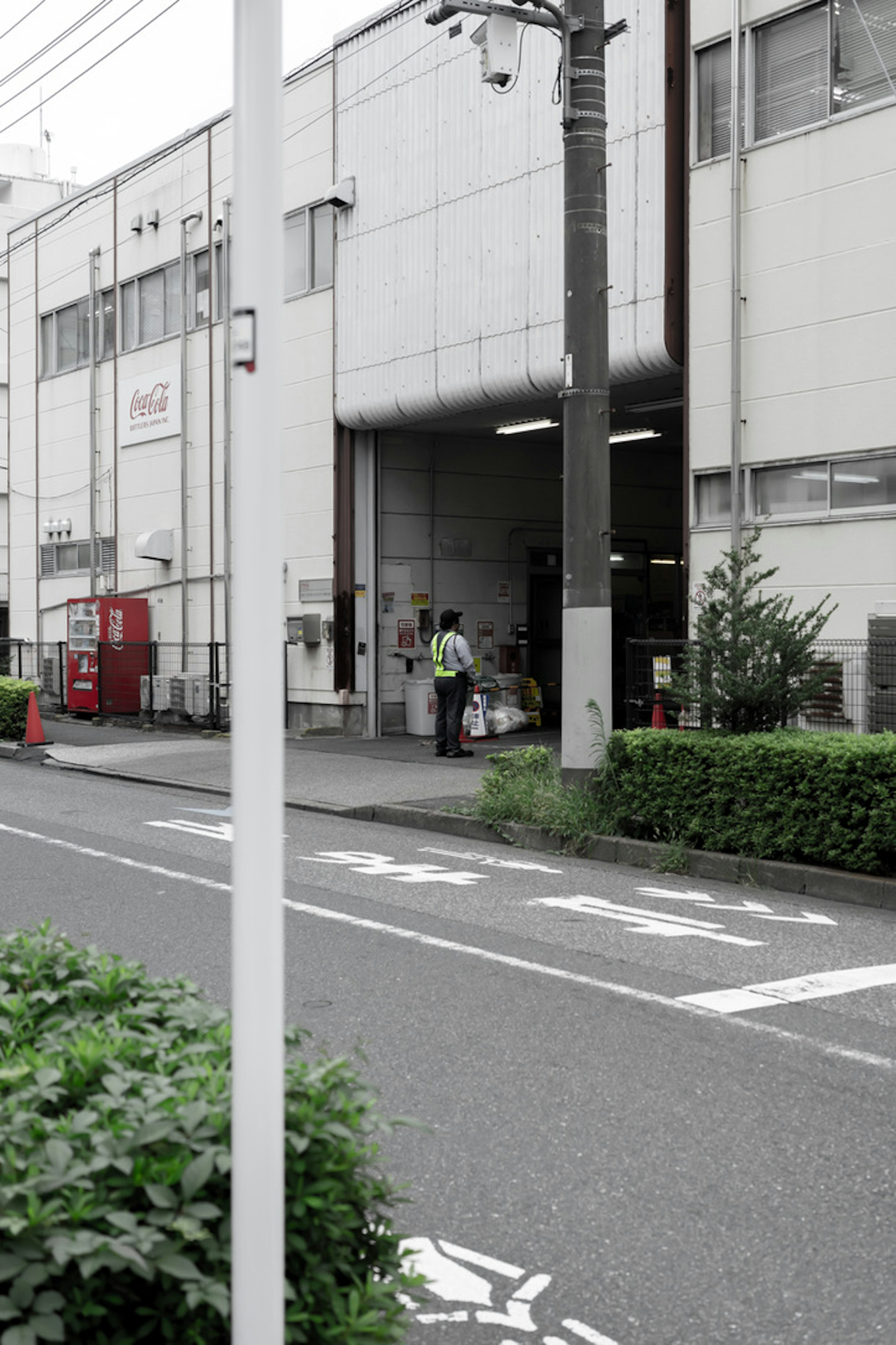 Arbeiter vor einer Fabrik mit nahegelegener Vegetation