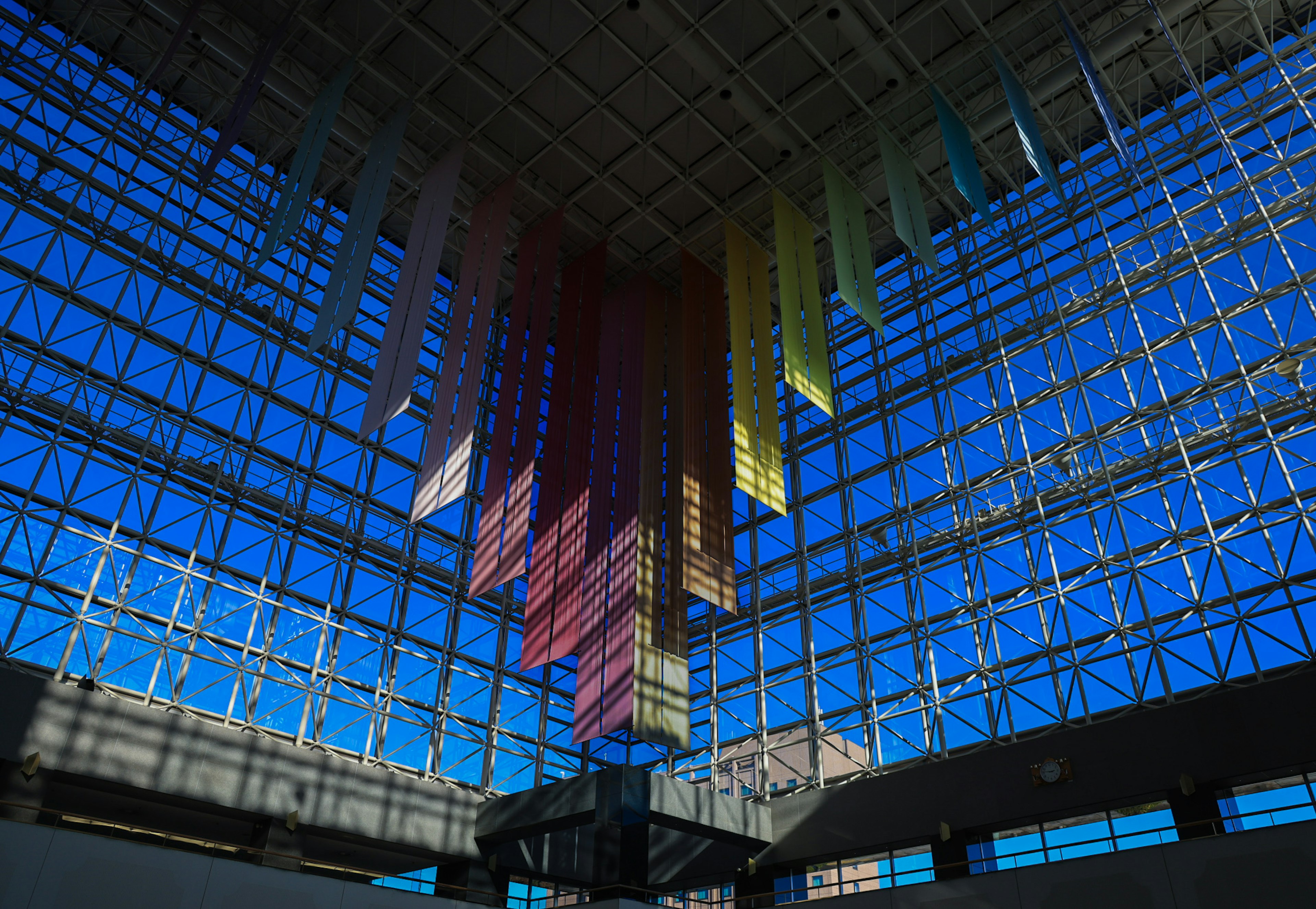 Spacious area under a transparent glass ceiling with colorful strips hanging down