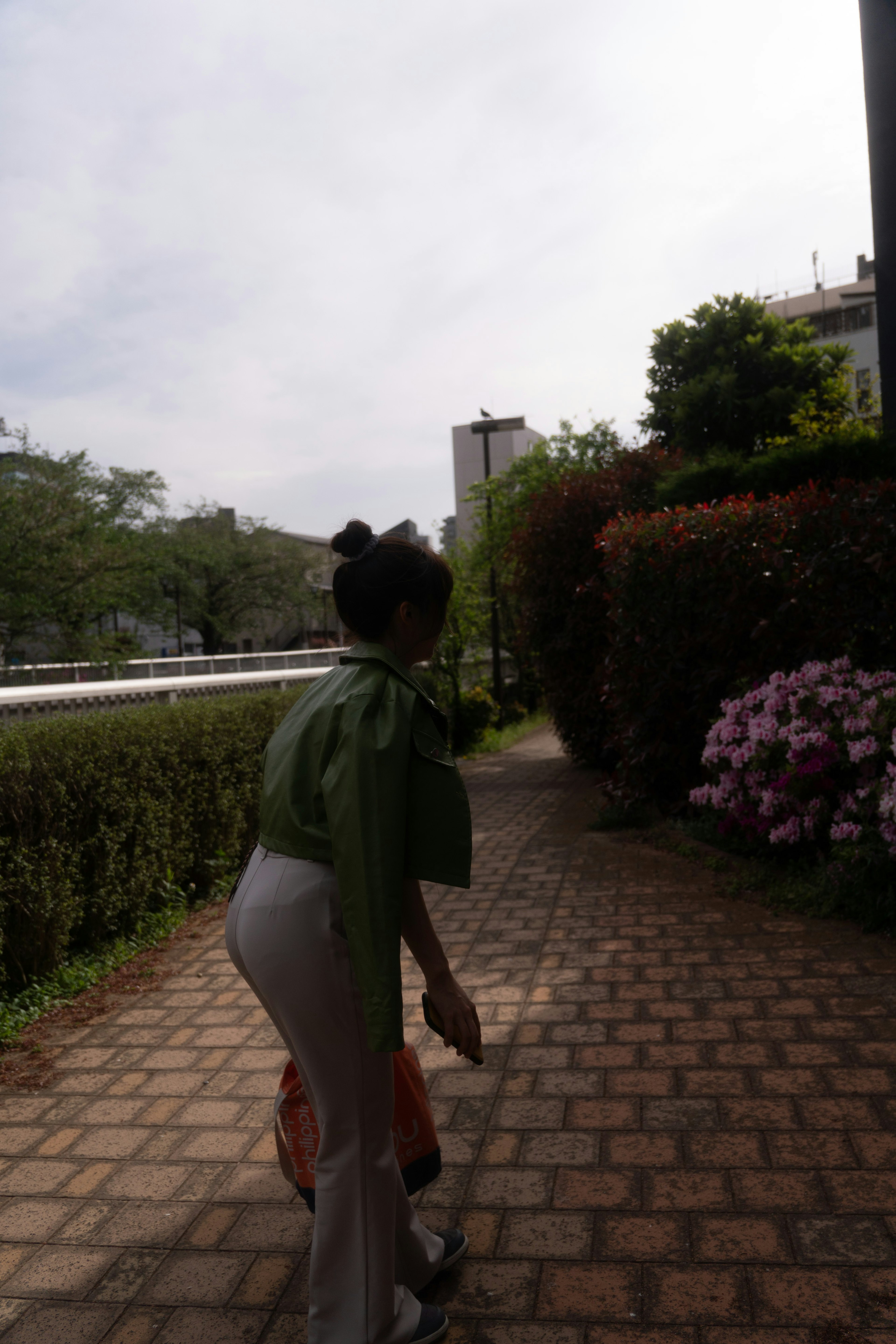 Une femme portant une cape verte marchant le long d'un chemin