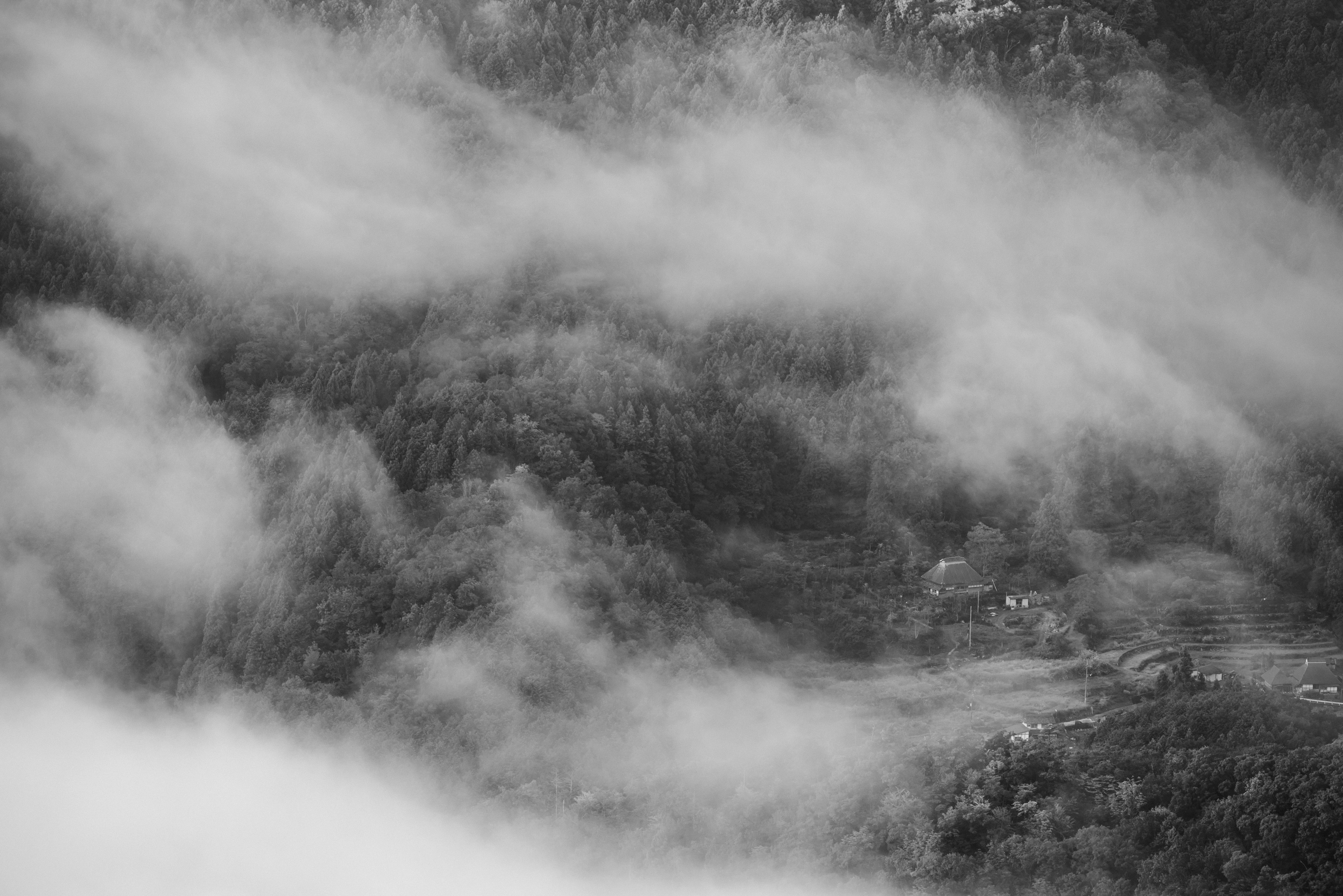 Paisaje montañoso envuelto en niebla con un pequeño pueblo