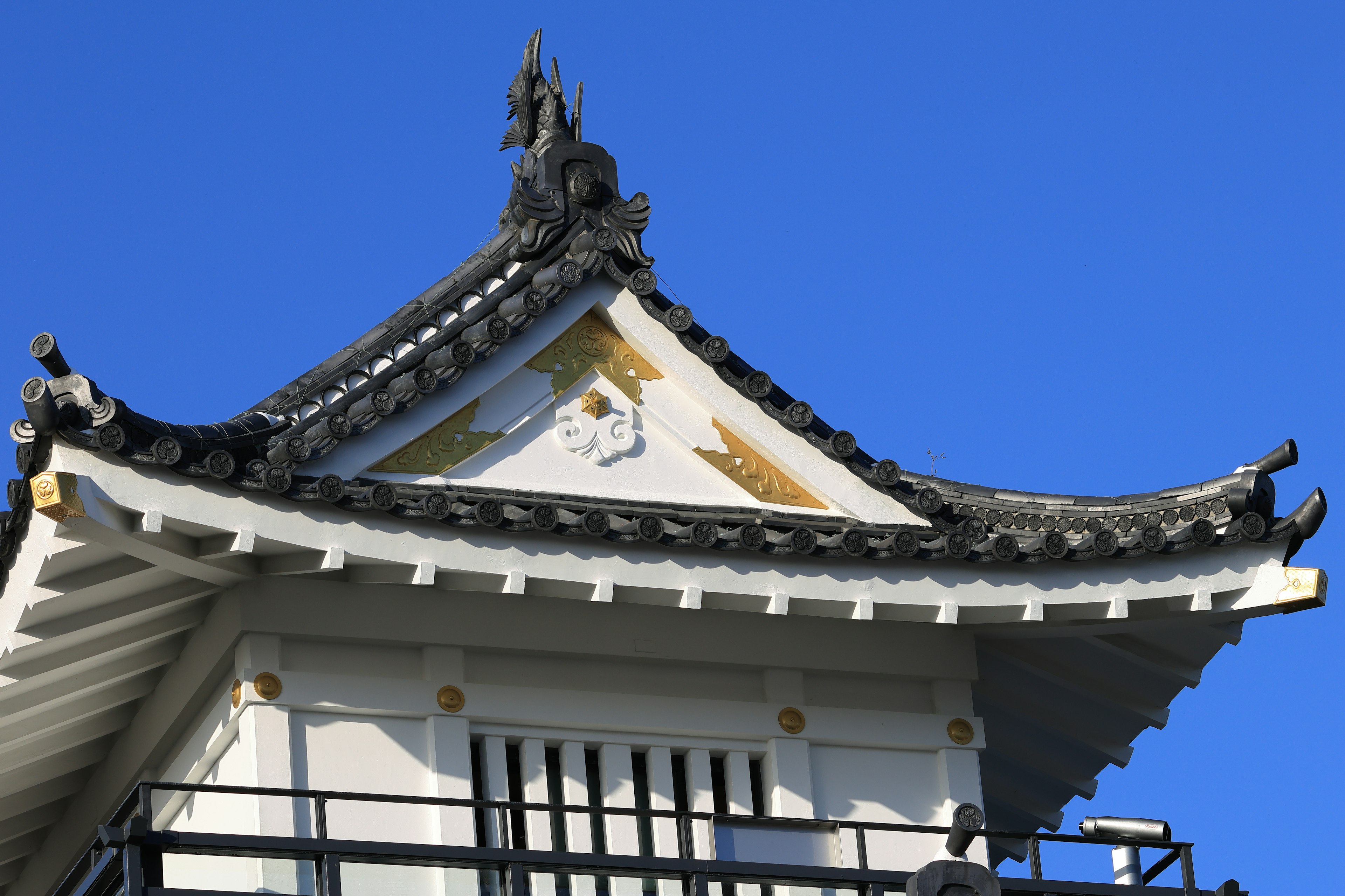 Vista detallada de un hermoso techo de castillo japonés bajo un cielo azul