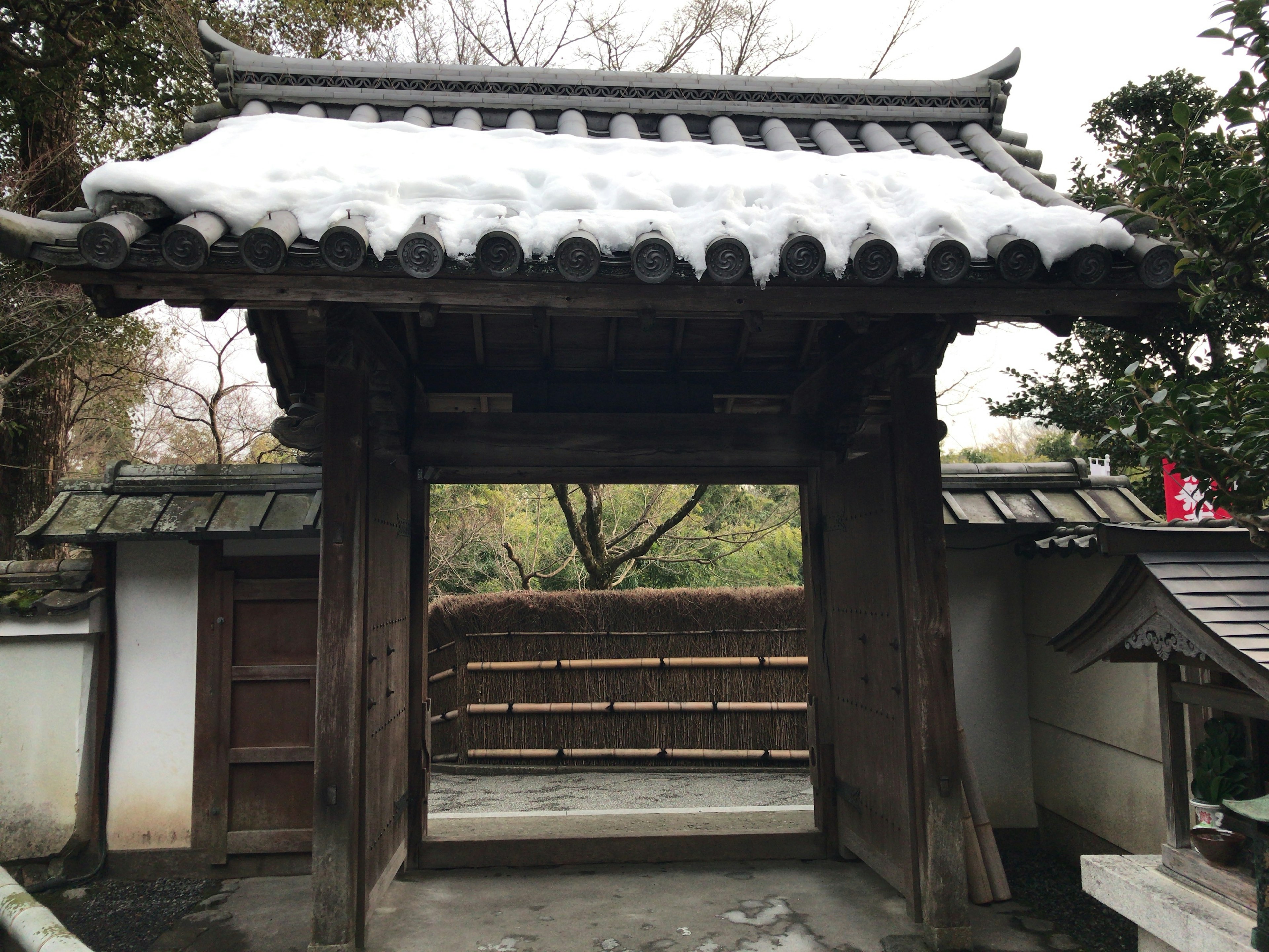 Puerta japonesa tradicional con nieve y vista al jardín