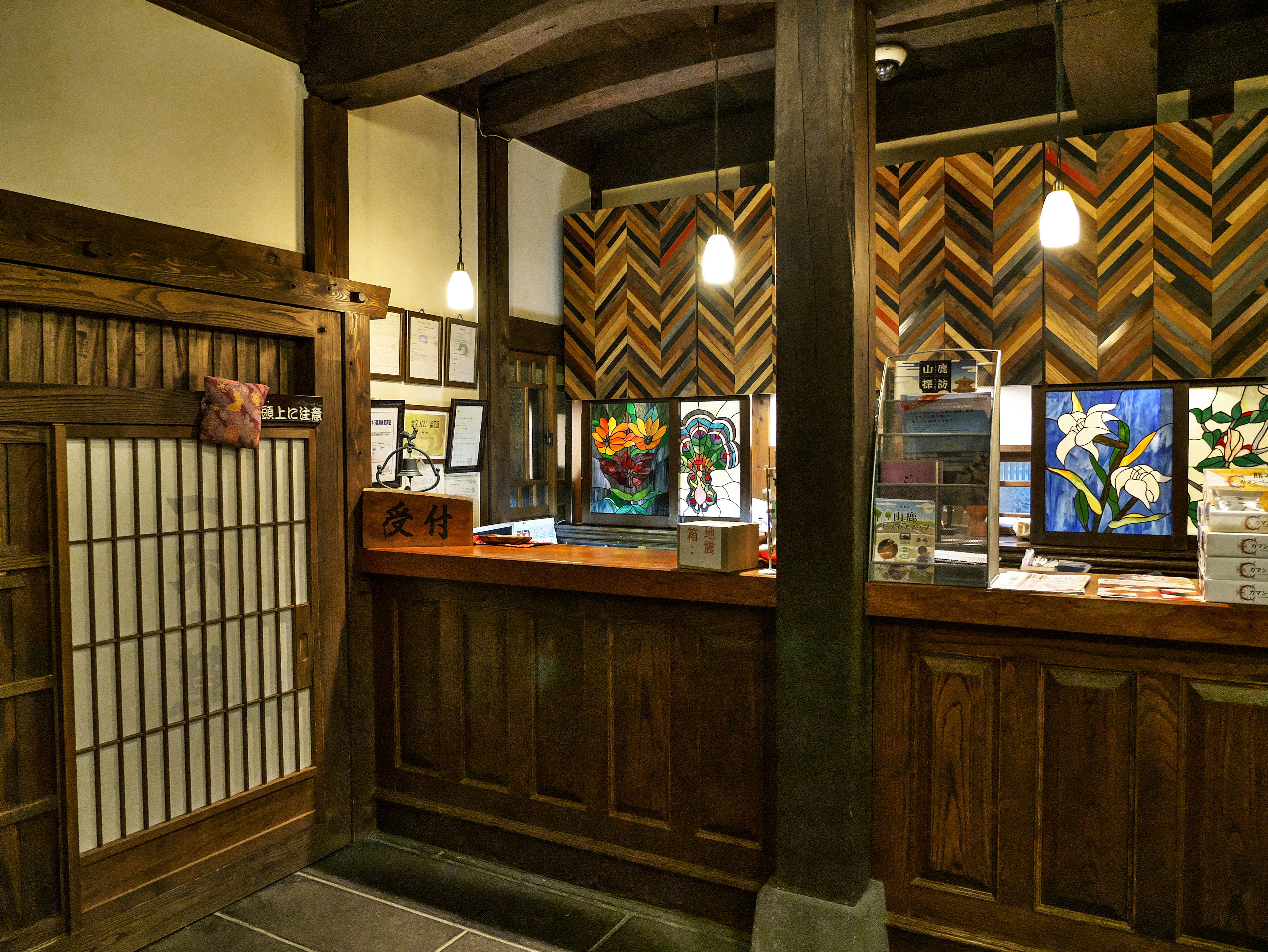 Reception area with wooden counter and chevron-patterned wall featuring artwork