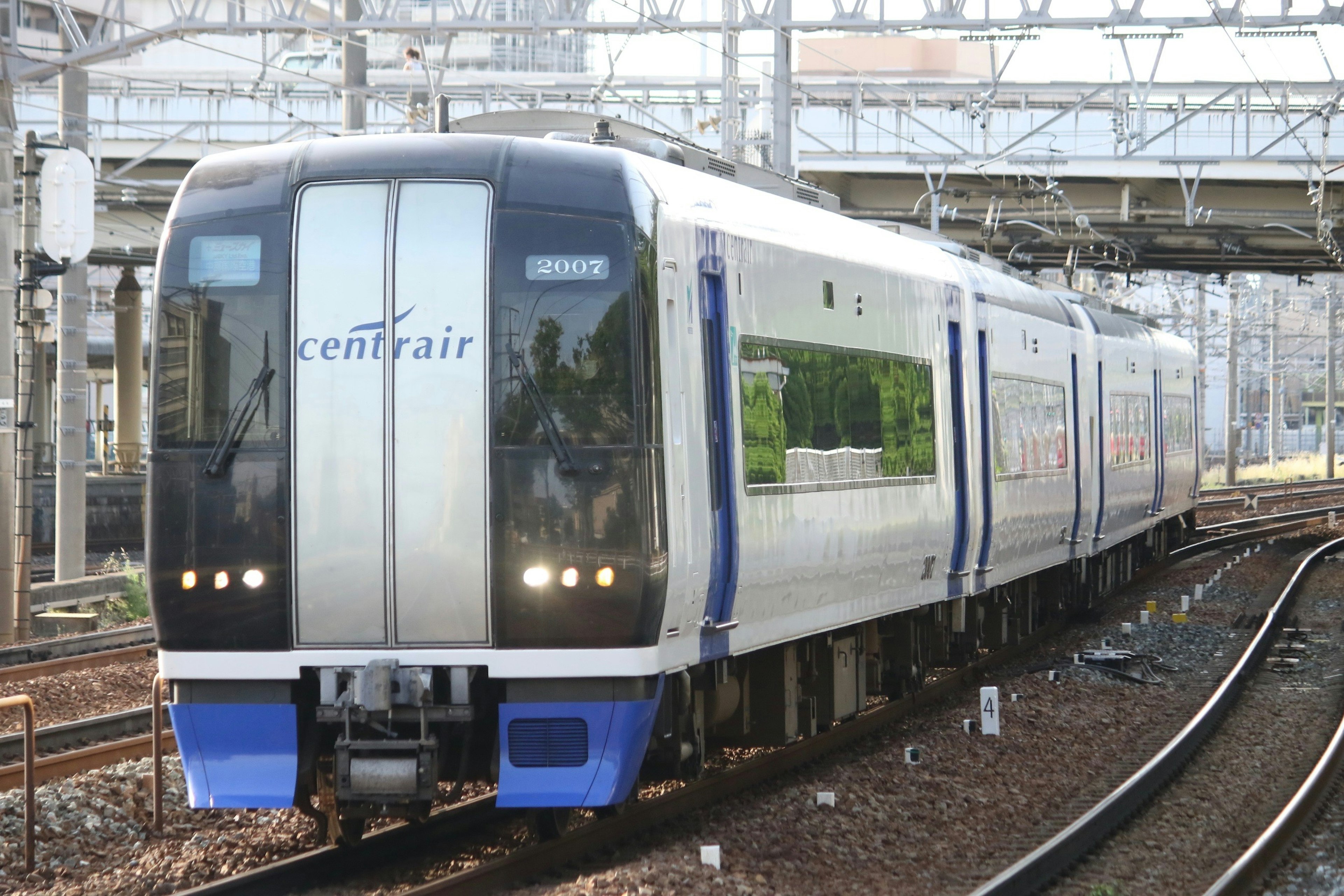 名古屋のセントレア行きの現代的な電車が線路を走っている