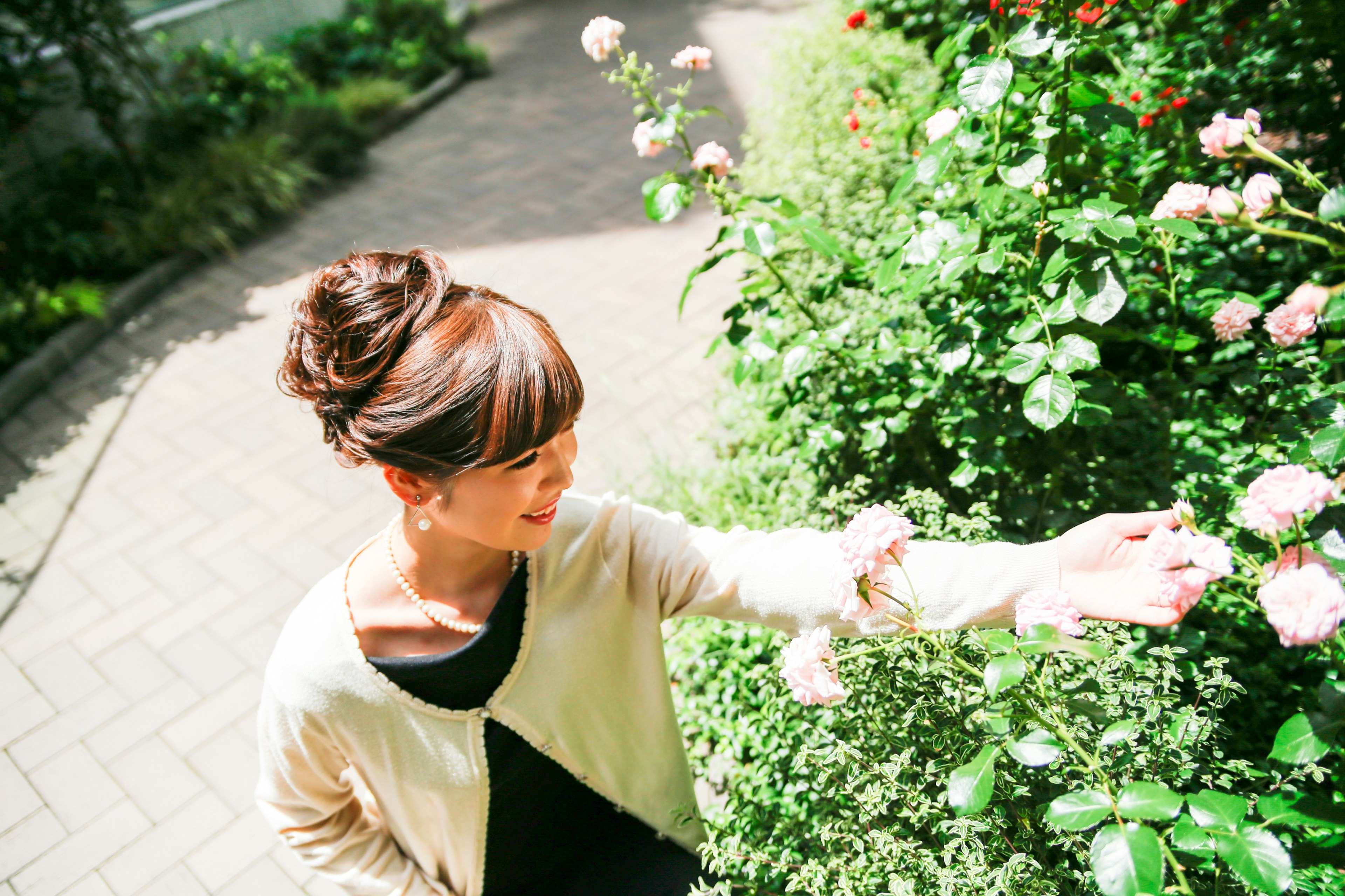 Una donna che si avvicina a toccare fiori in un bellissimo giardino