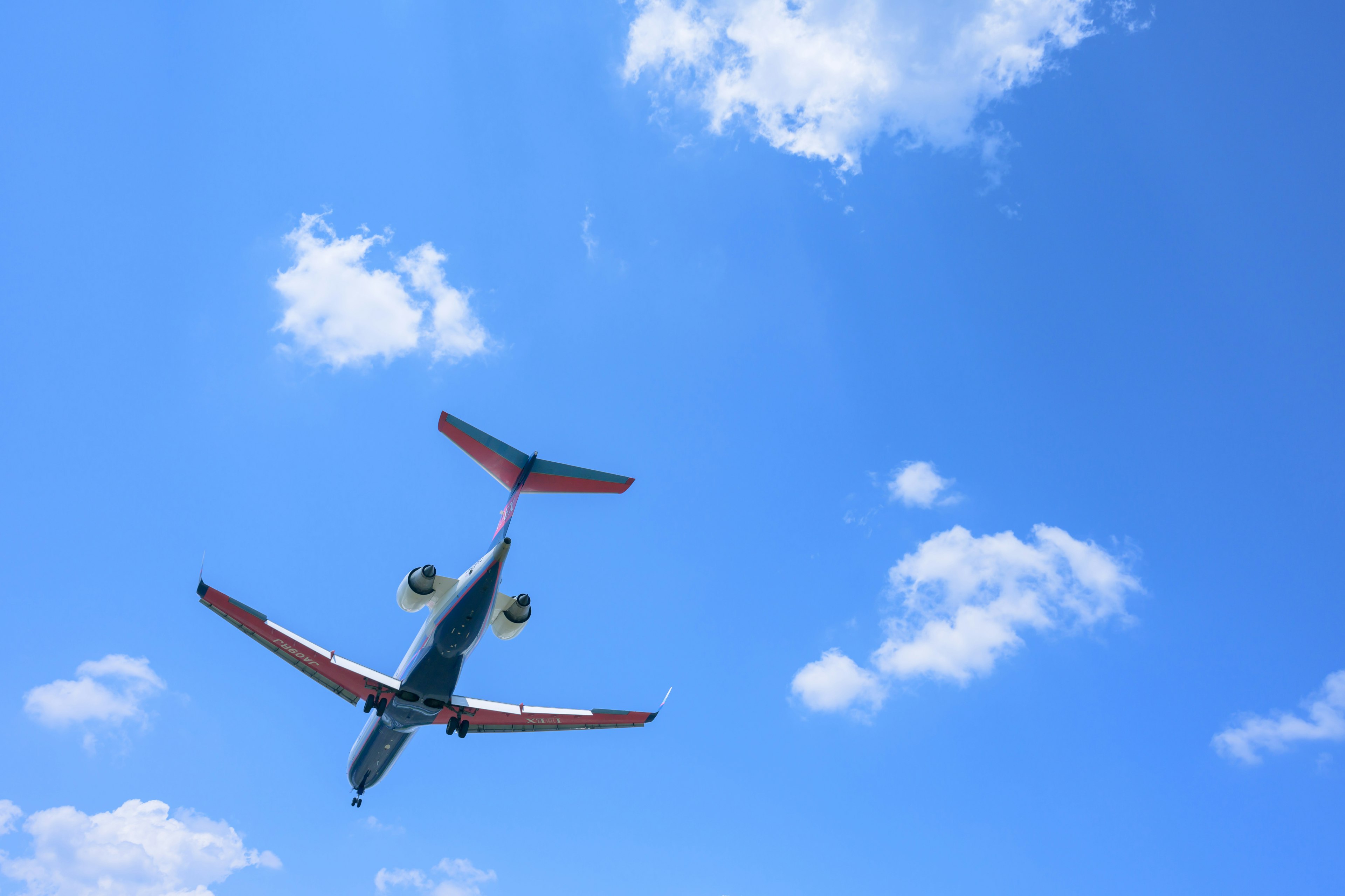 Un aereo che vola nel cielo blu con nuvole