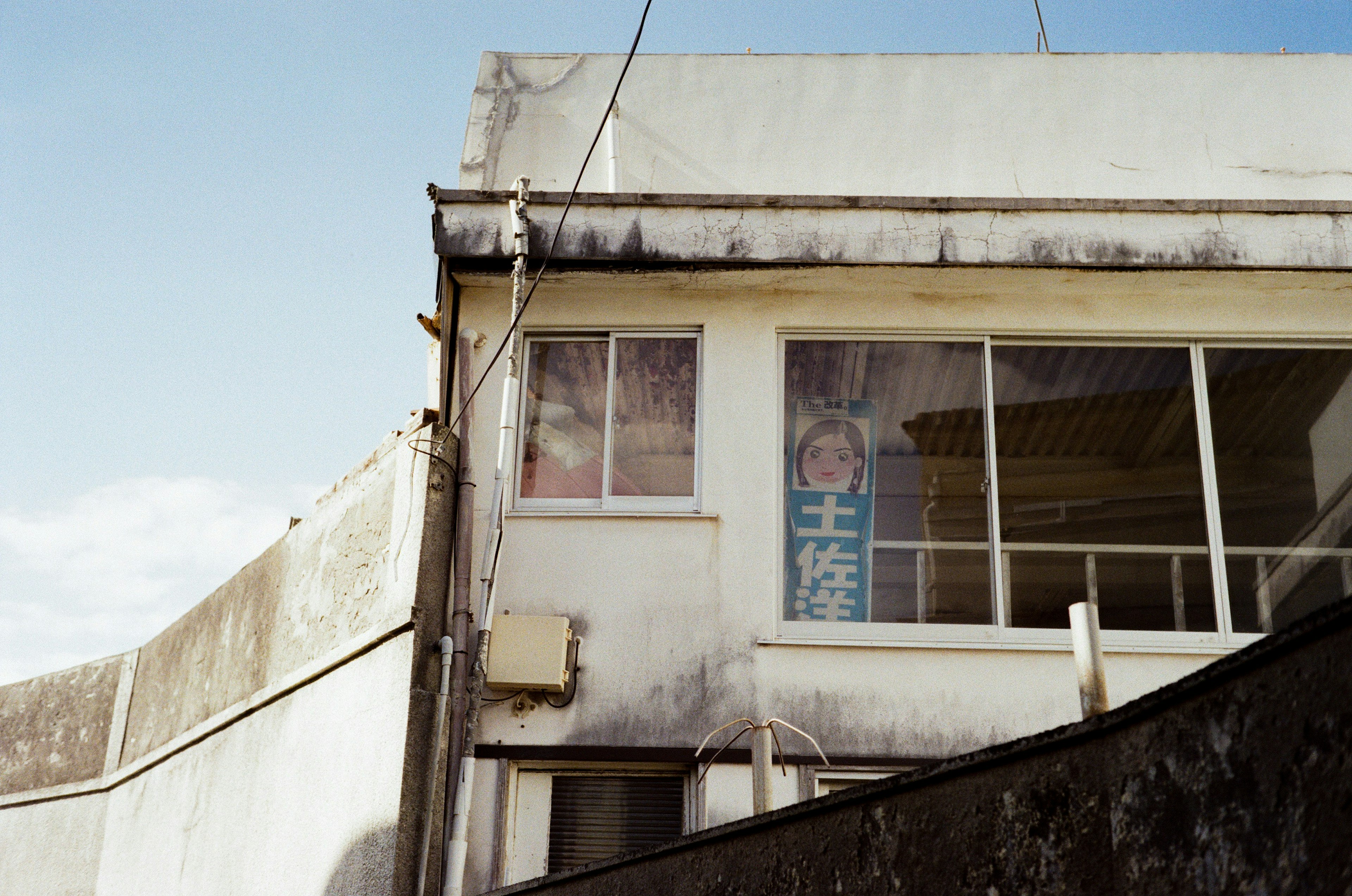 Exterior view of an old building with windows and a sign