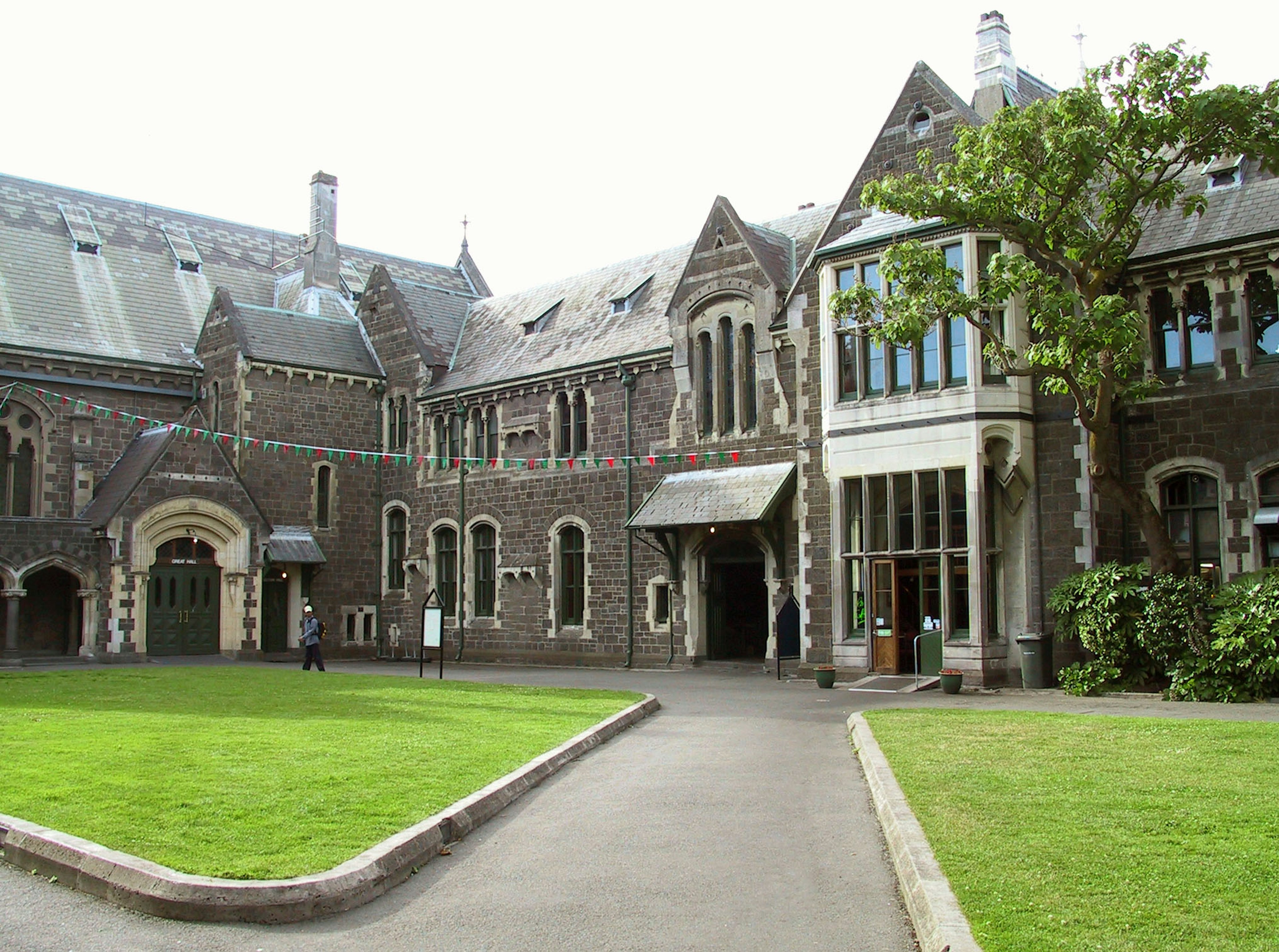 Historic stone building with lush green lawn and detailed architecture