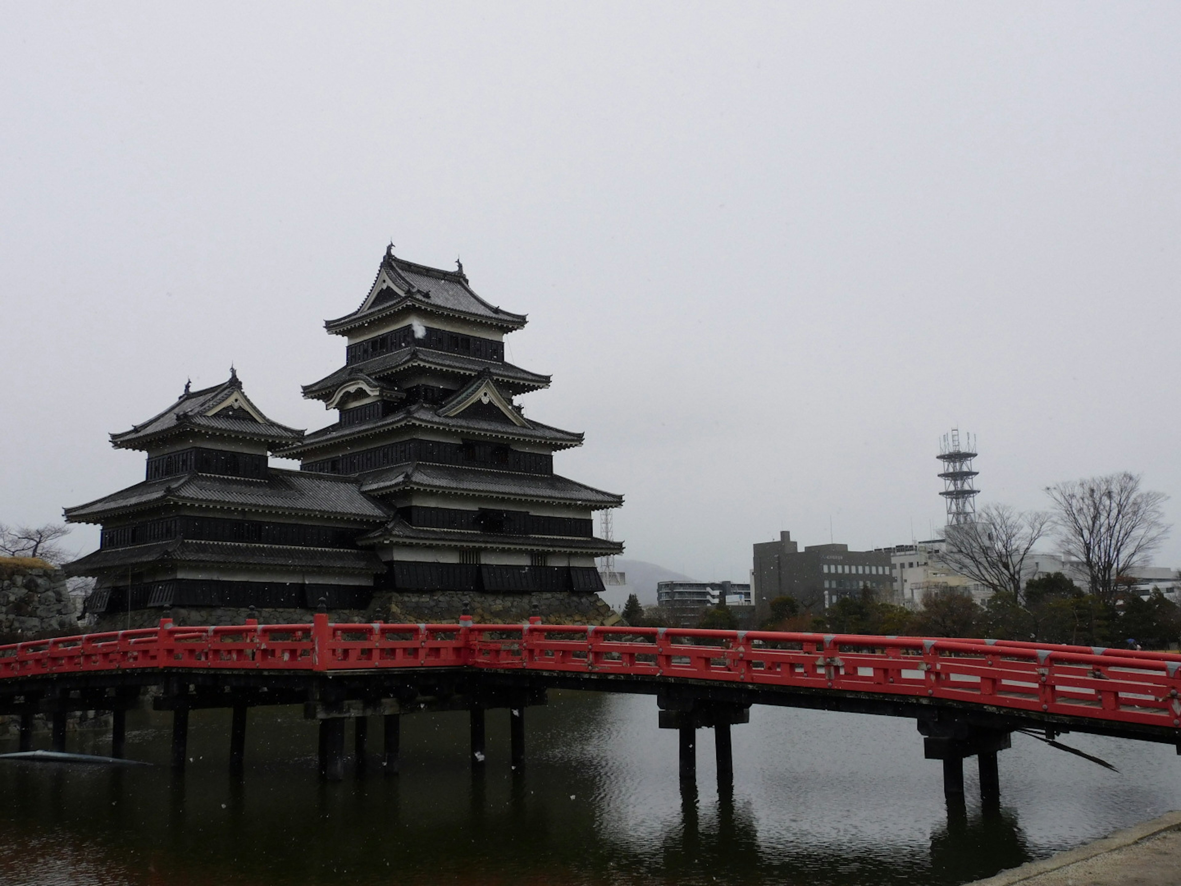 Kastil Matsumoto dengan jembatan merah di bawah langit mendung