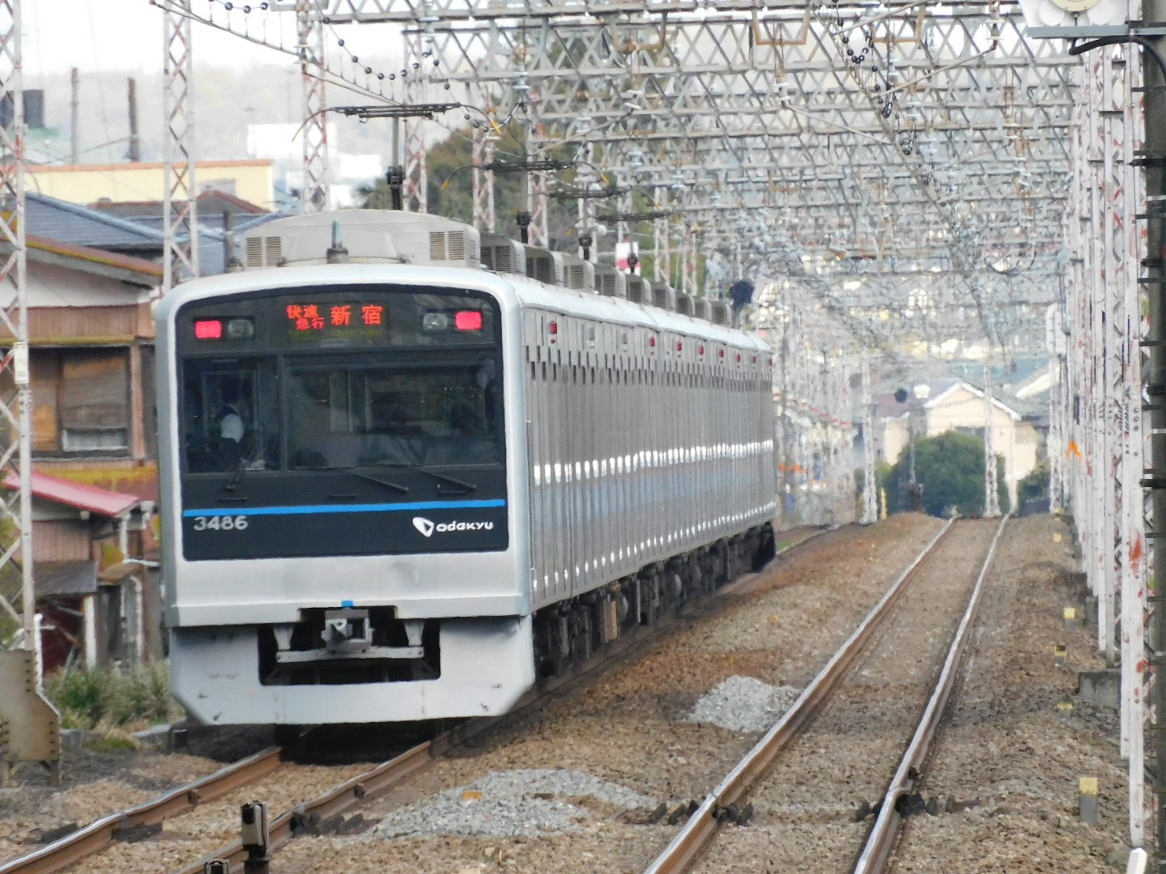 Treno che corre su binari con paesaggio urbano sullo sfondo