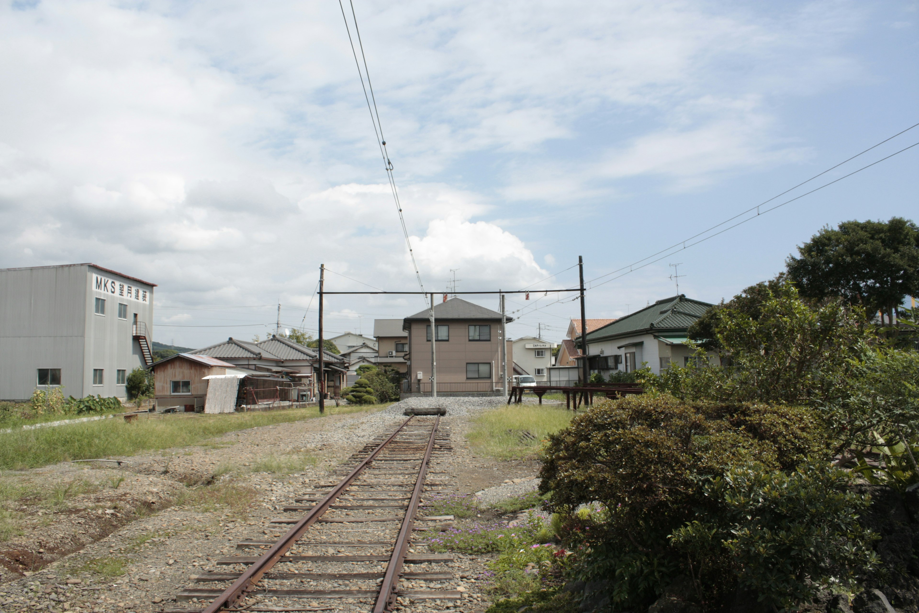 Vías de tren en una zona residencial con cielo azul