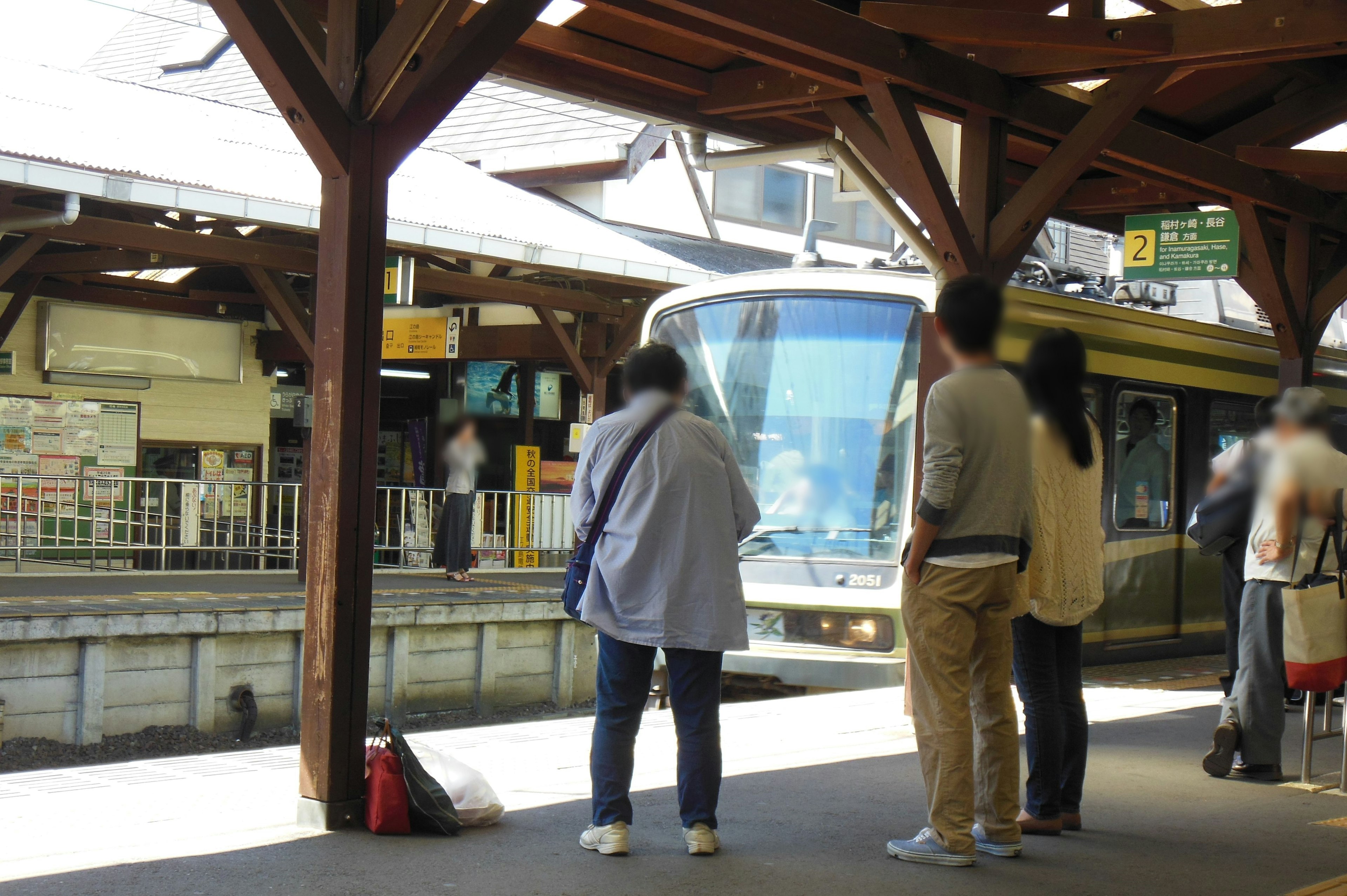 People waiting on a train platform with an approaching train