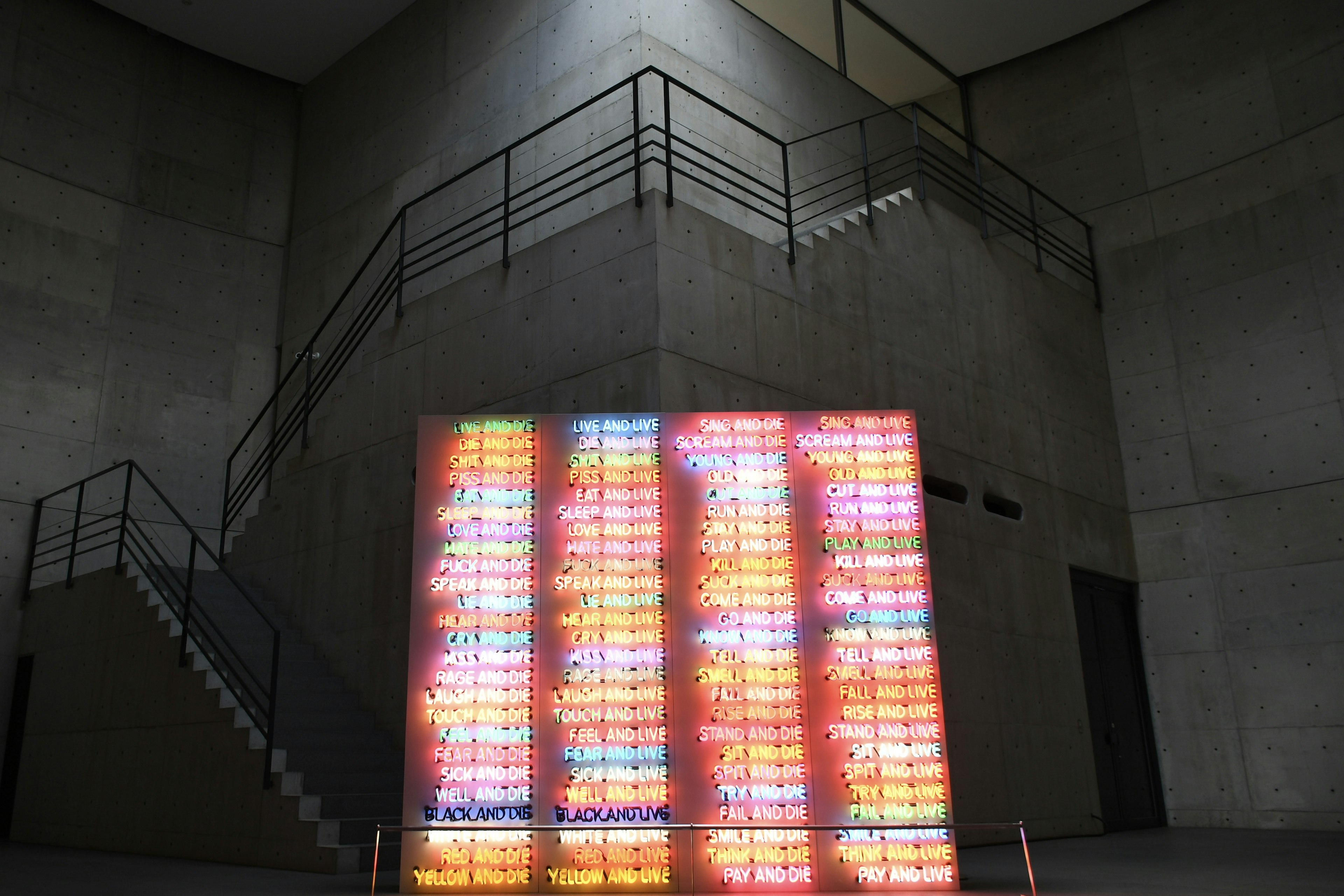 Colorful light art installation in a modern museum interior with concrete walls