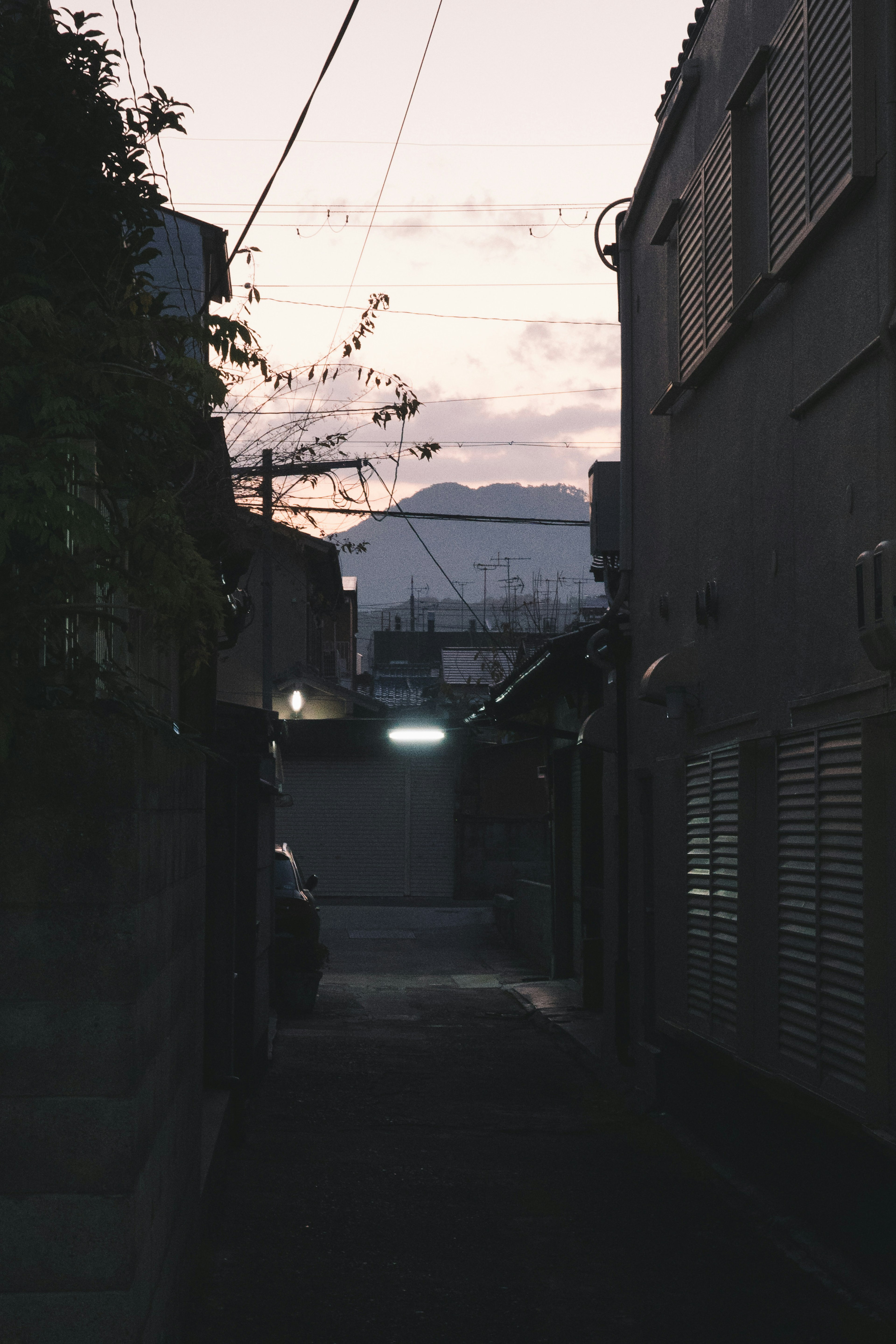 Narrow alleyway with distant mountain silhouette at sunset