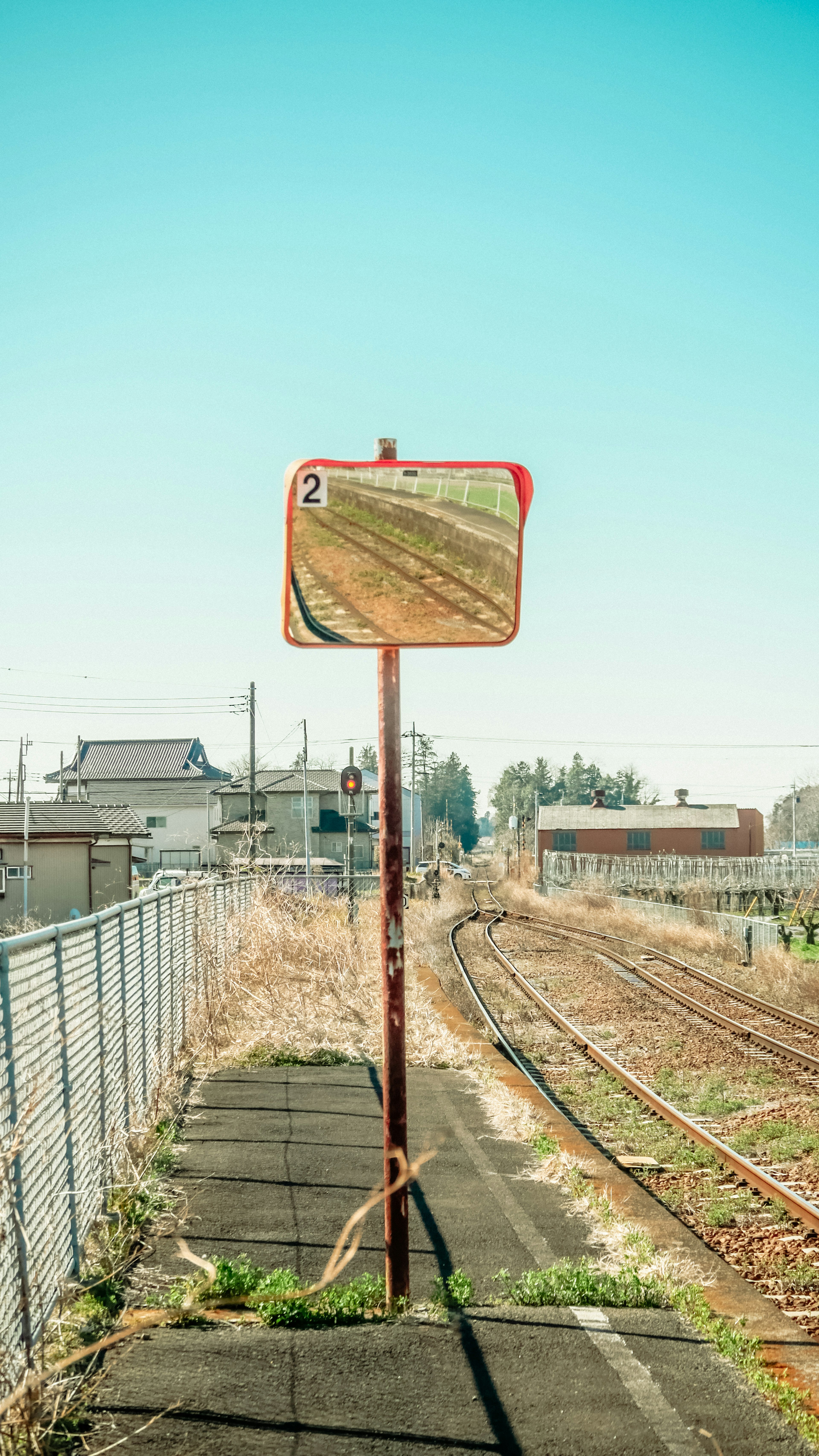 Ein altes Signalbrett, das die Gleise spiegelt