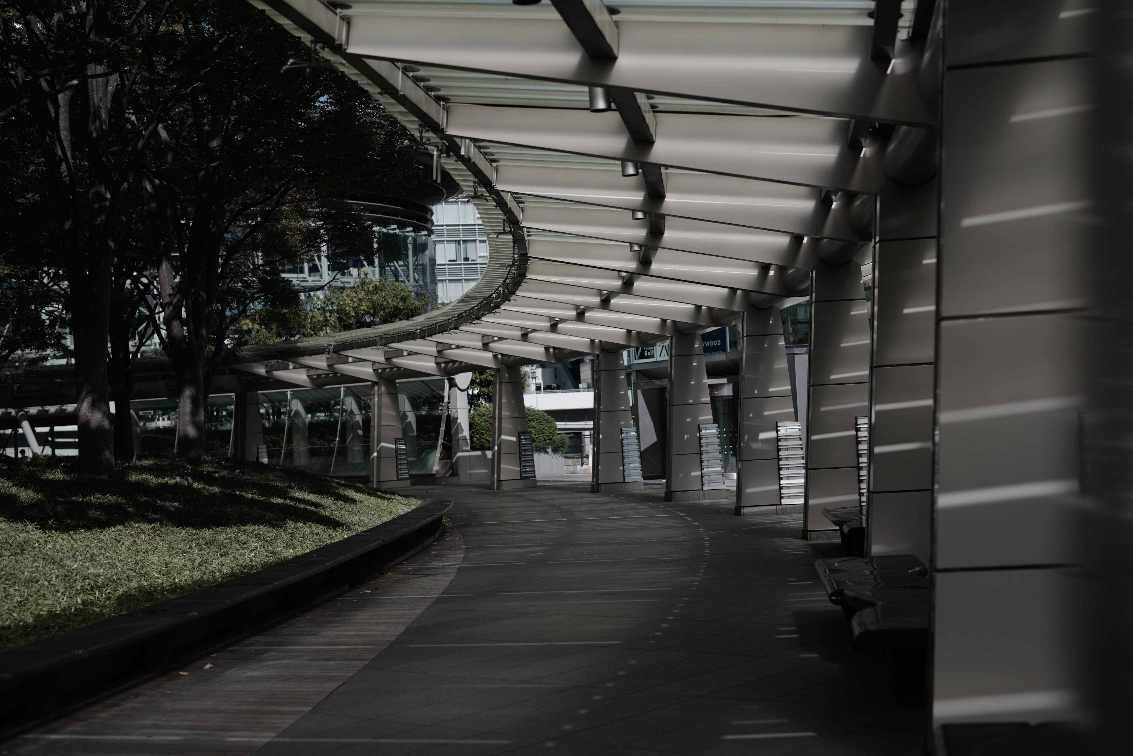 Passerelle courbe avec architecture moderne et verdure environnante