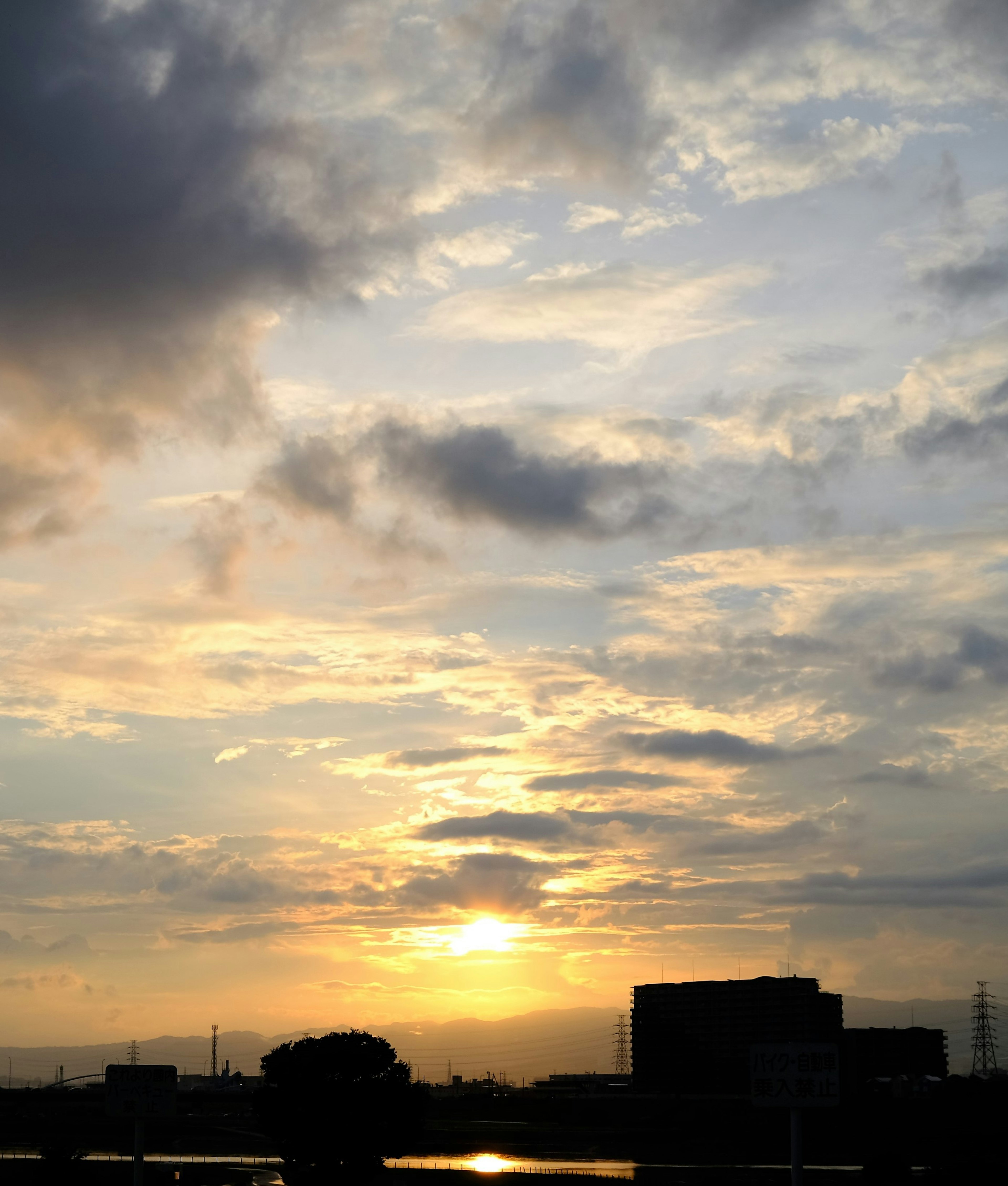 Cielo de atardecer con nubes y silueta de edificios