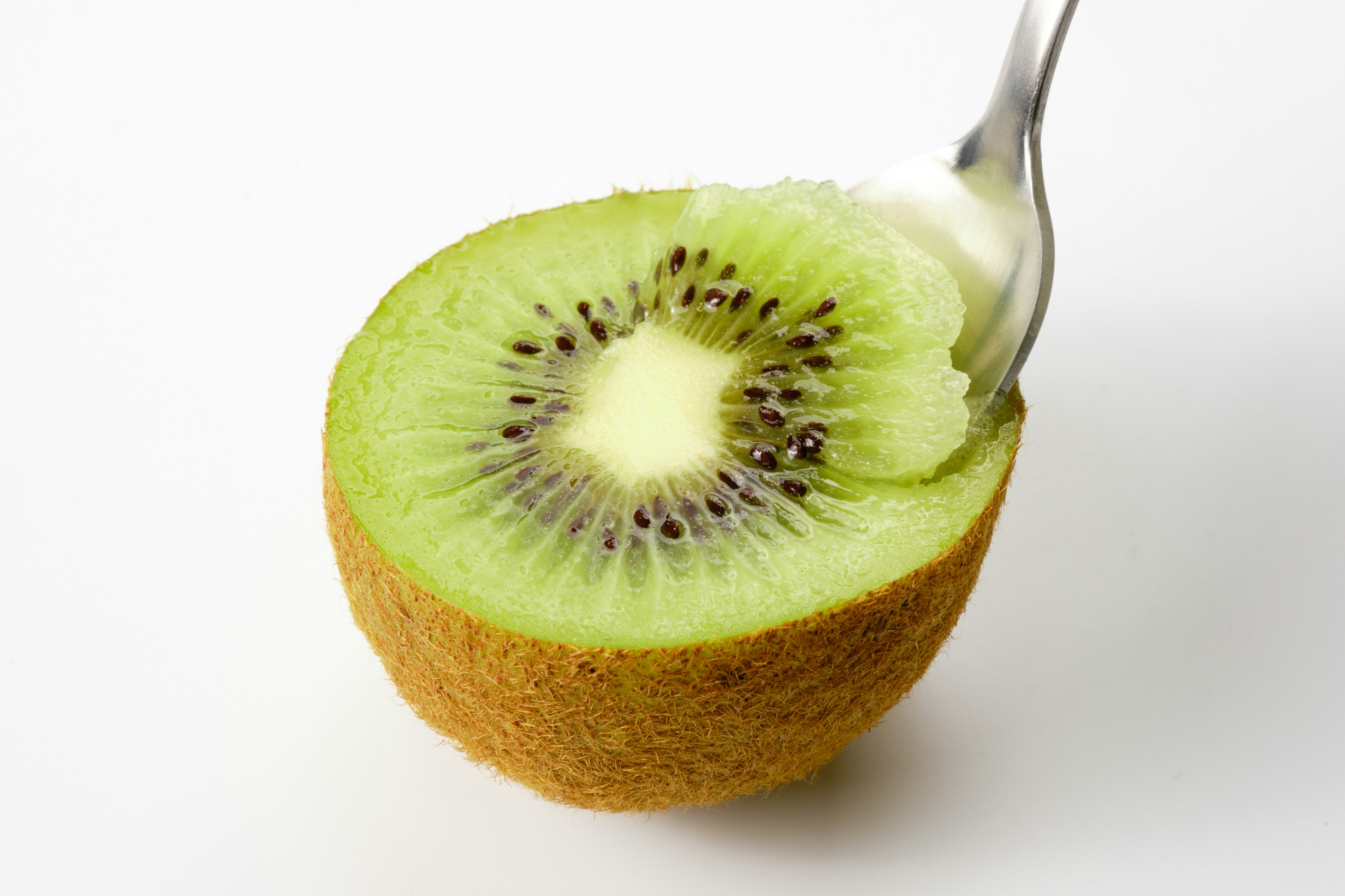 Kiwi yang dipotong setengah dengan sendok