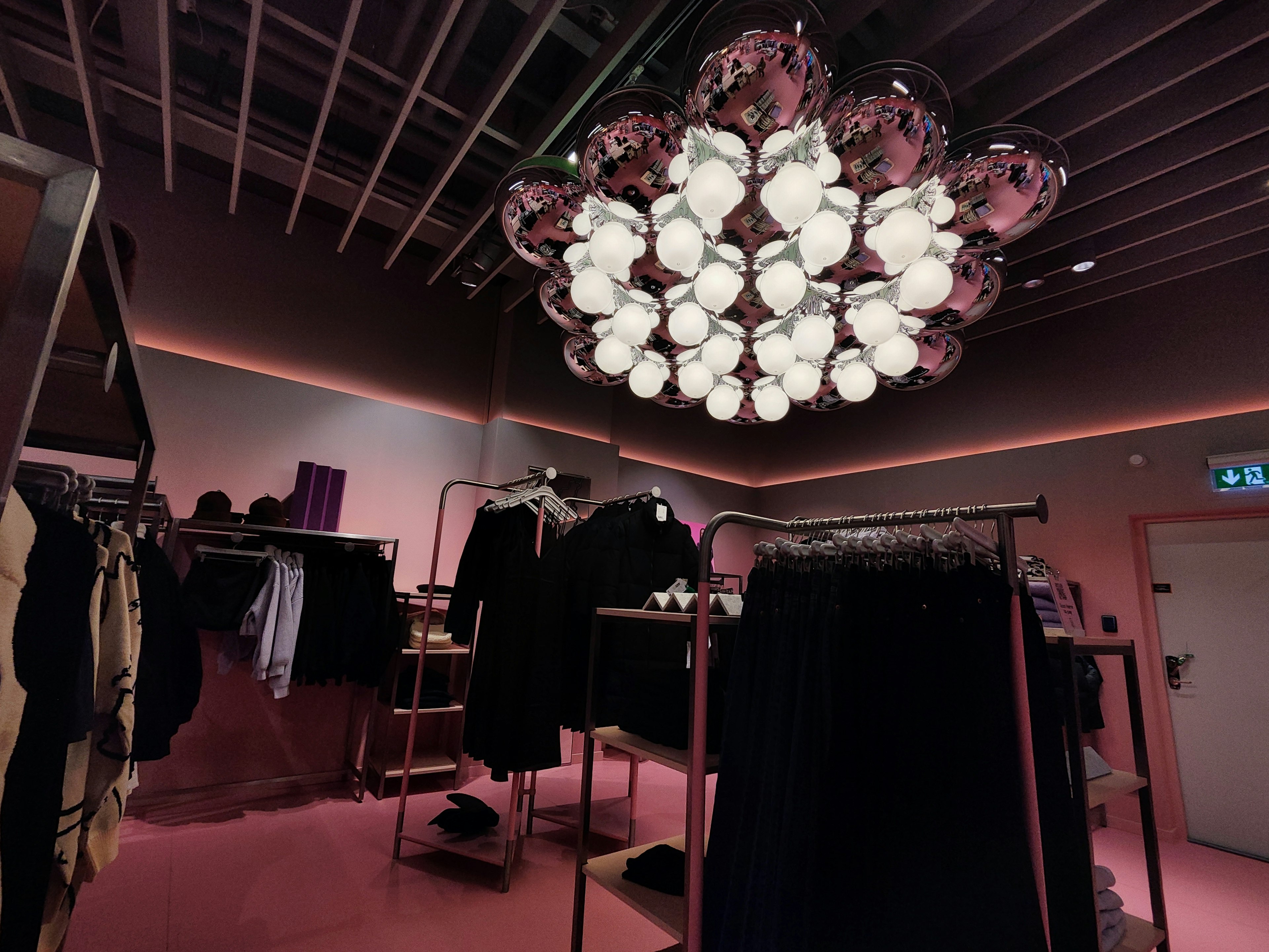 Intérieur d'un magasin de vêtements moderne avec un éclairage rose et un luminaire unique