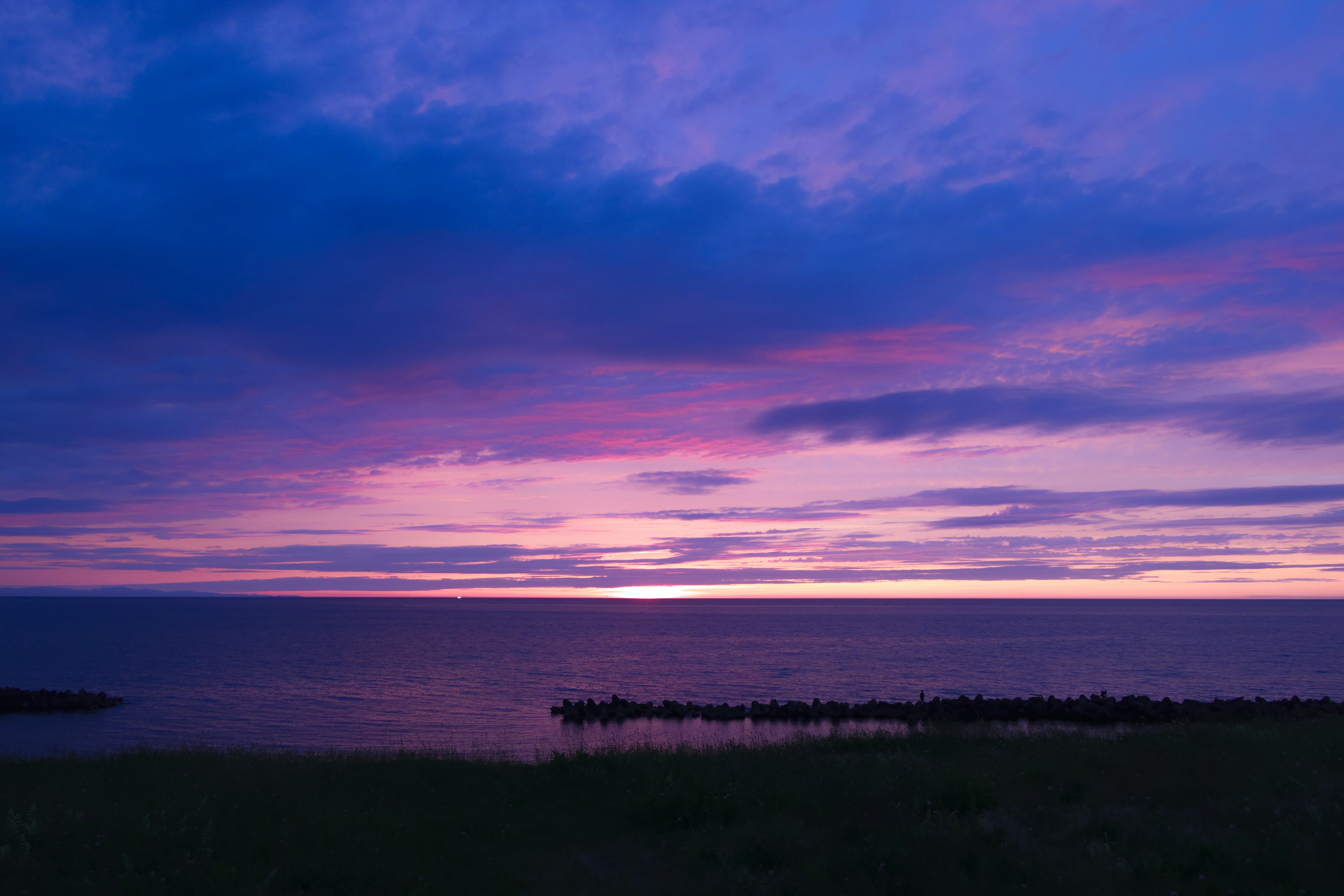 紫色の夕焼けと静かな海の風景