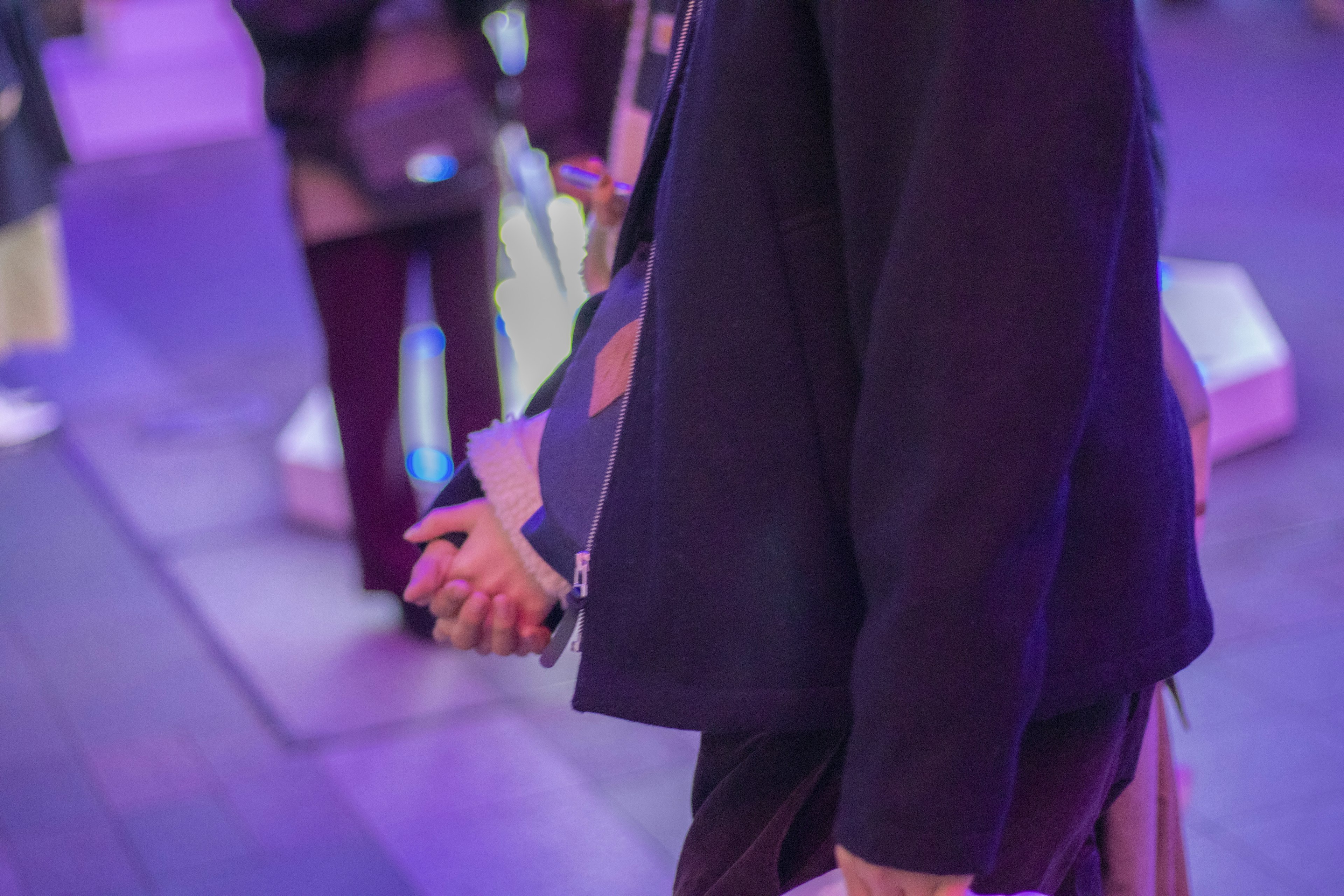 Couple holding hands in profile with purple lighting