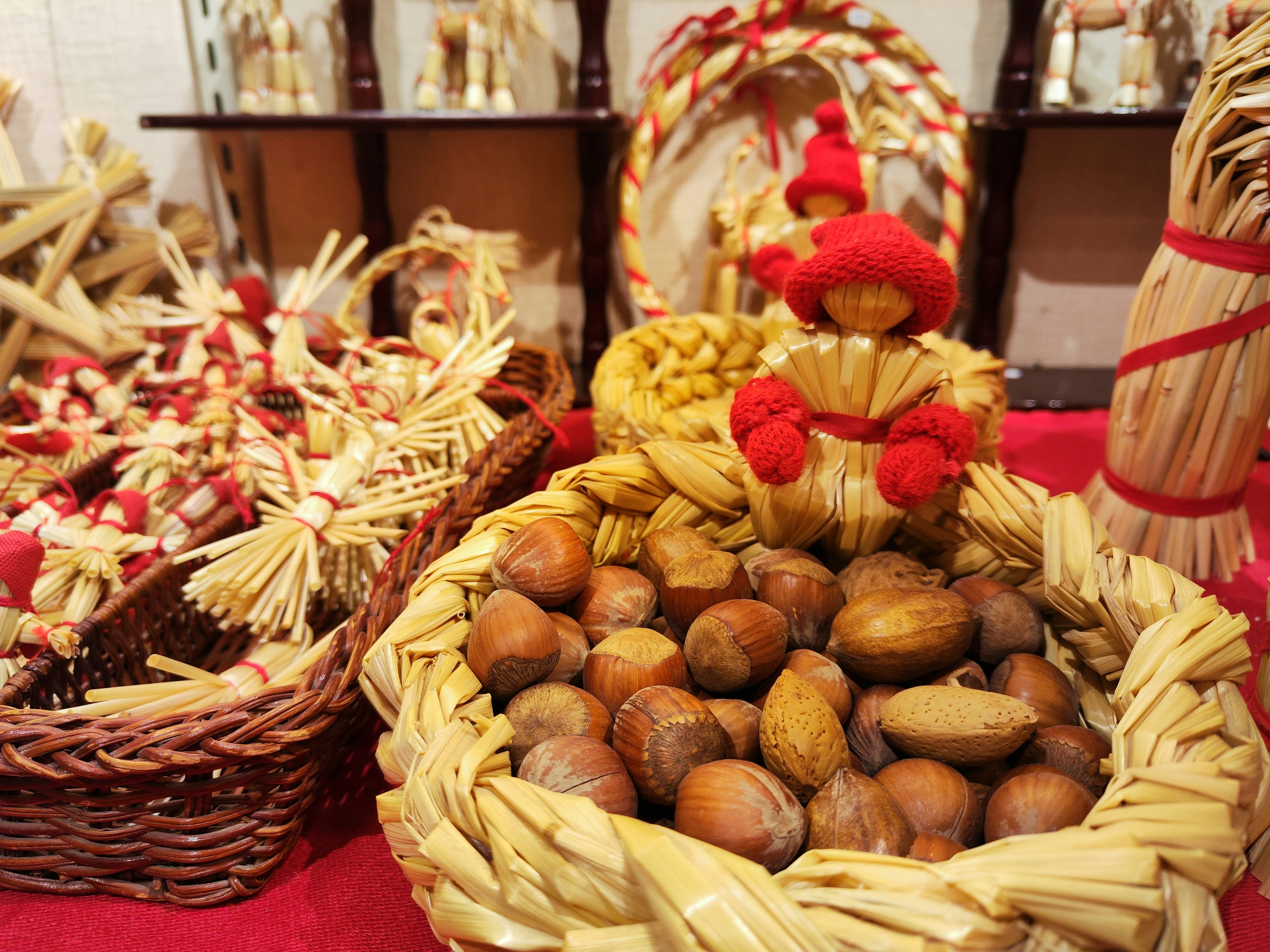 Una exhibición vibrante con una cesta de paja llena de nueces y figuras decorativas de paja