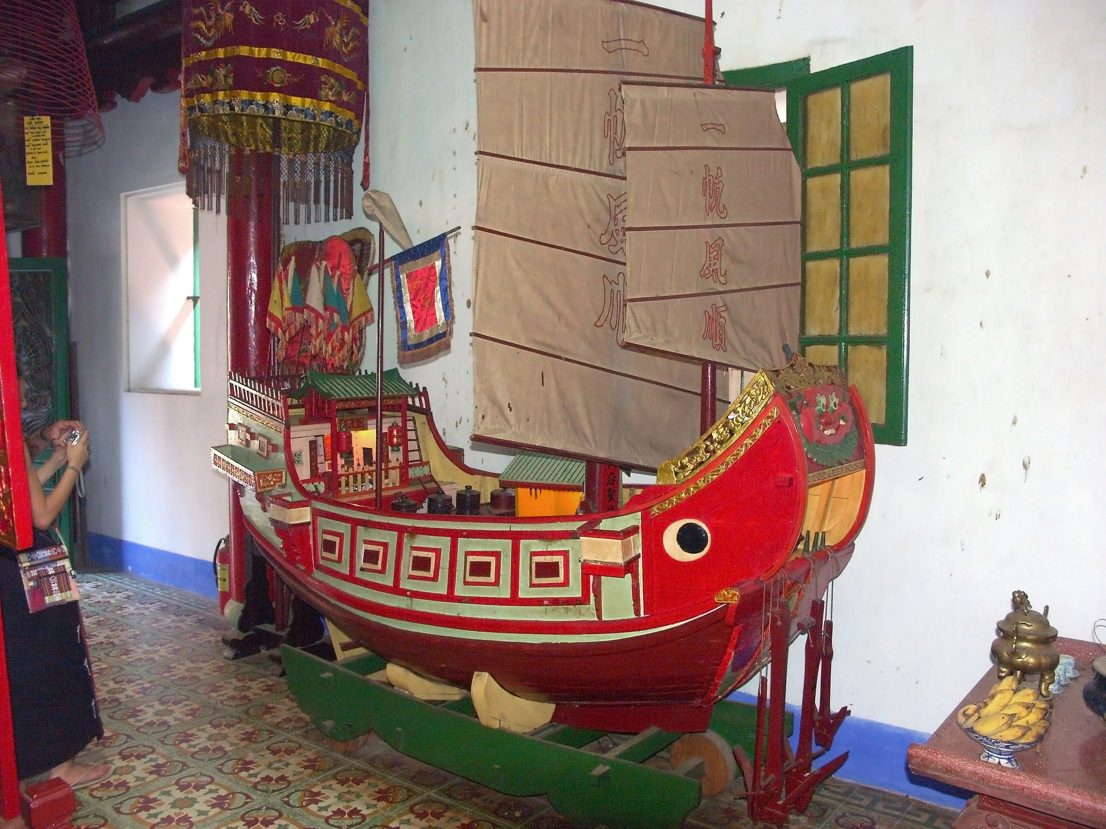 Un modèle de bateau rouge exposé à l'intérieur avec des éléments de design traditionnels