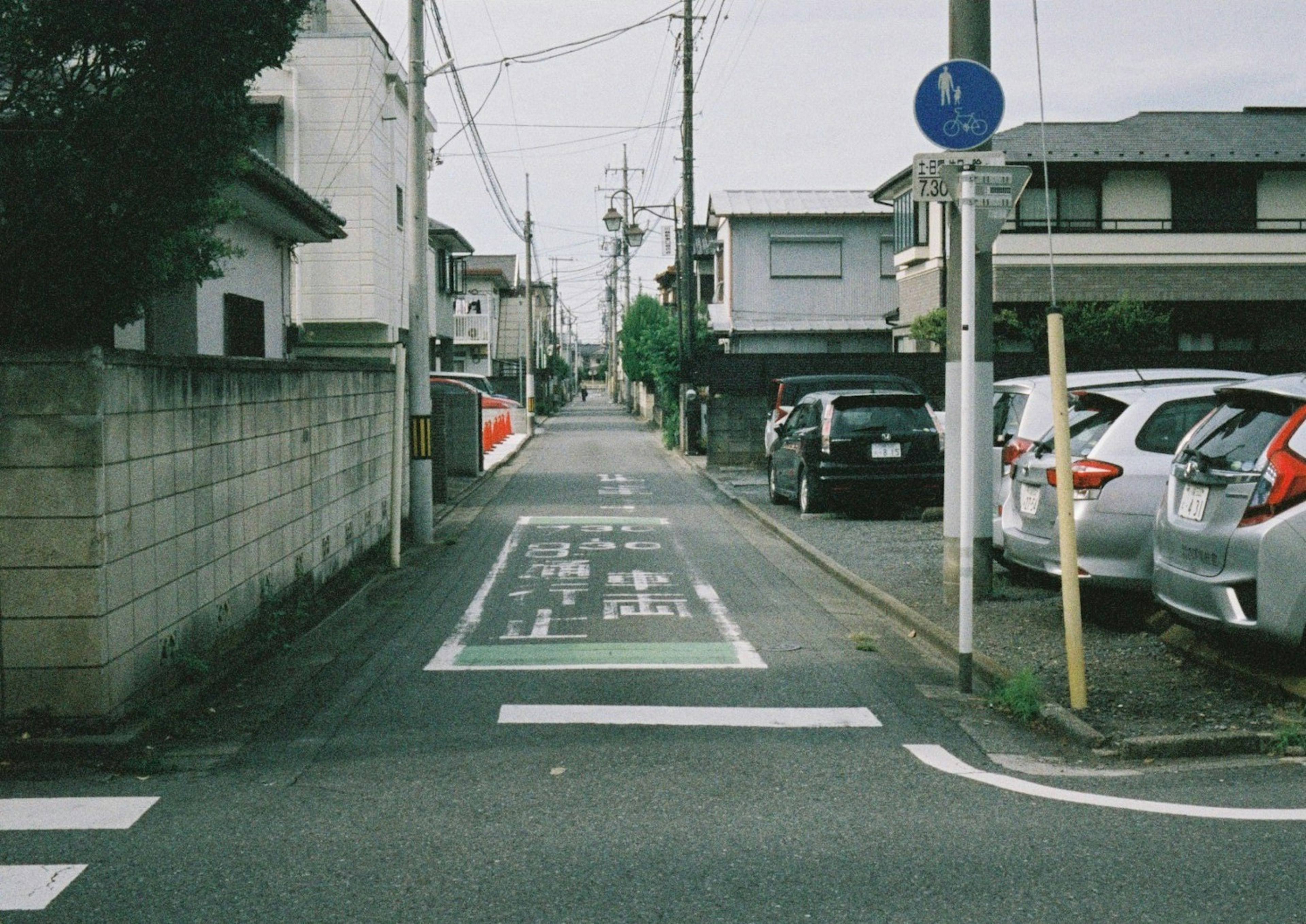 住宅街の狭い道路にある駐車スペースと交通標識