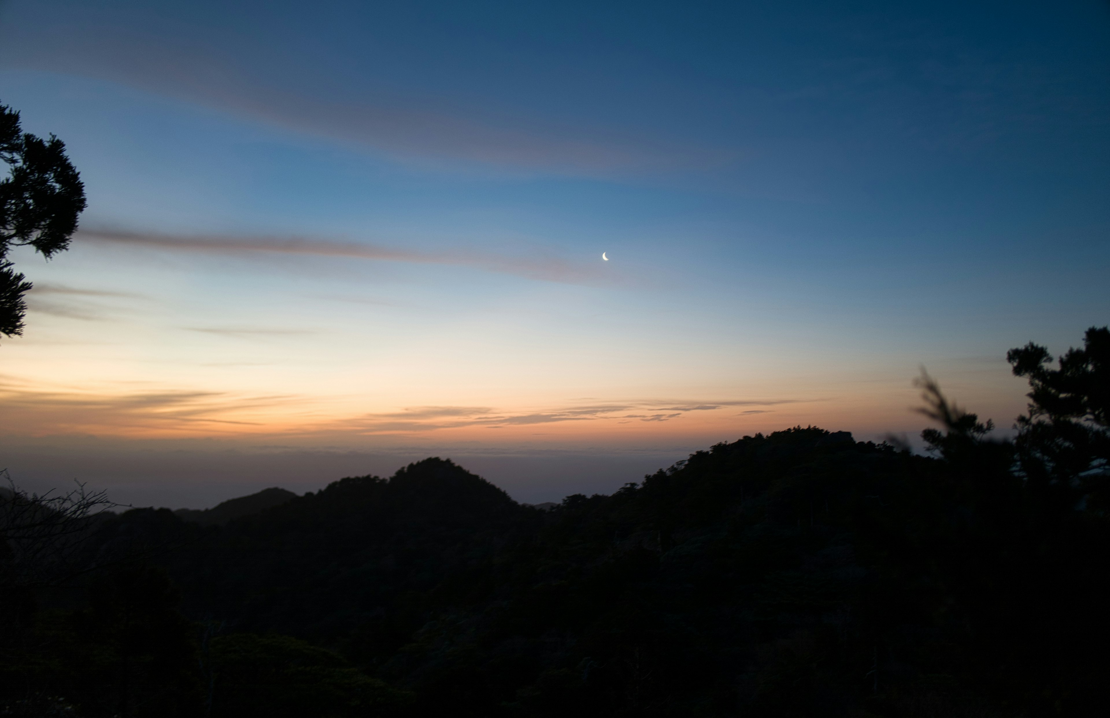 美しい夕焼けと山々のシルエットが見える風景