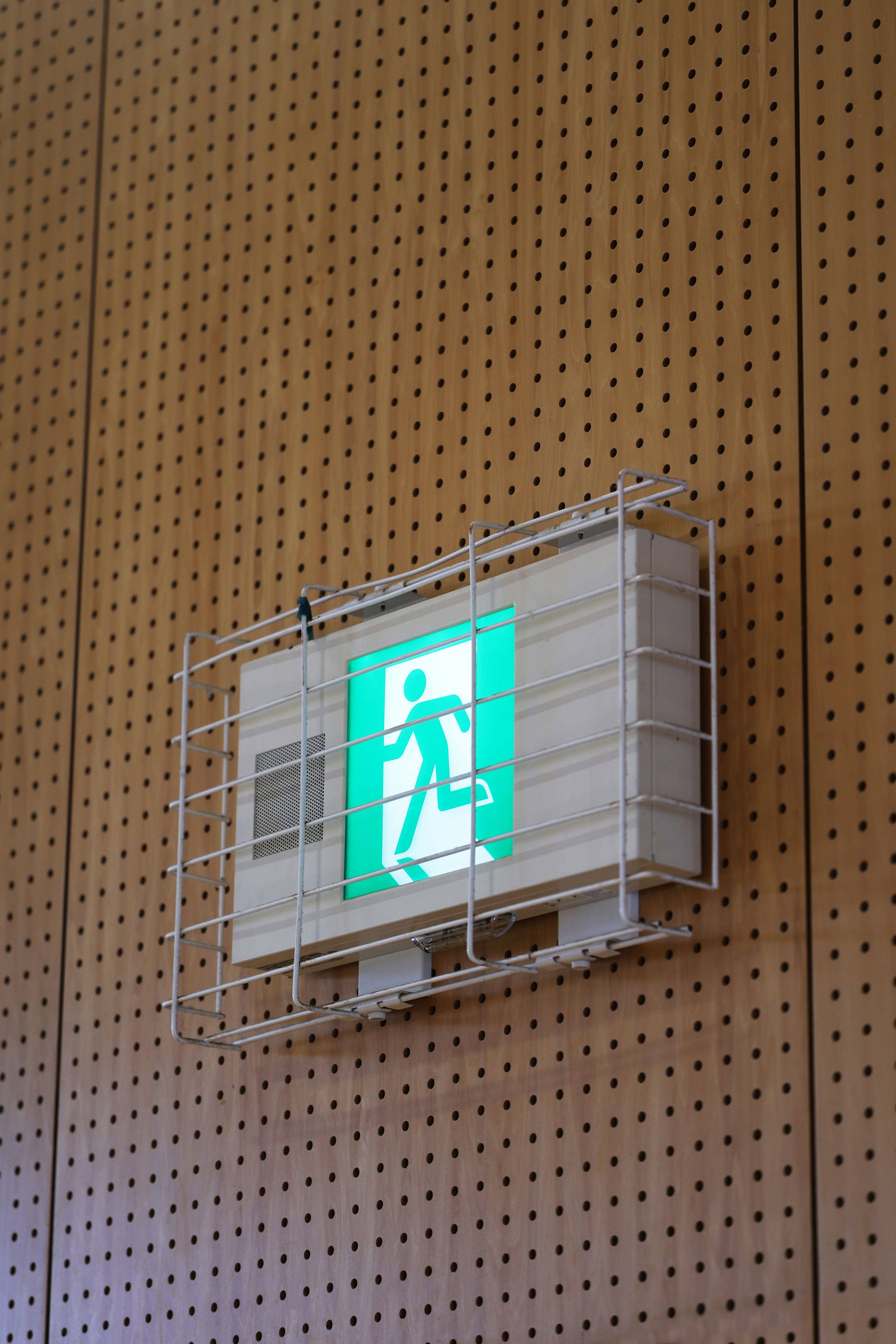 Green exit sign mounted on a wooden wall