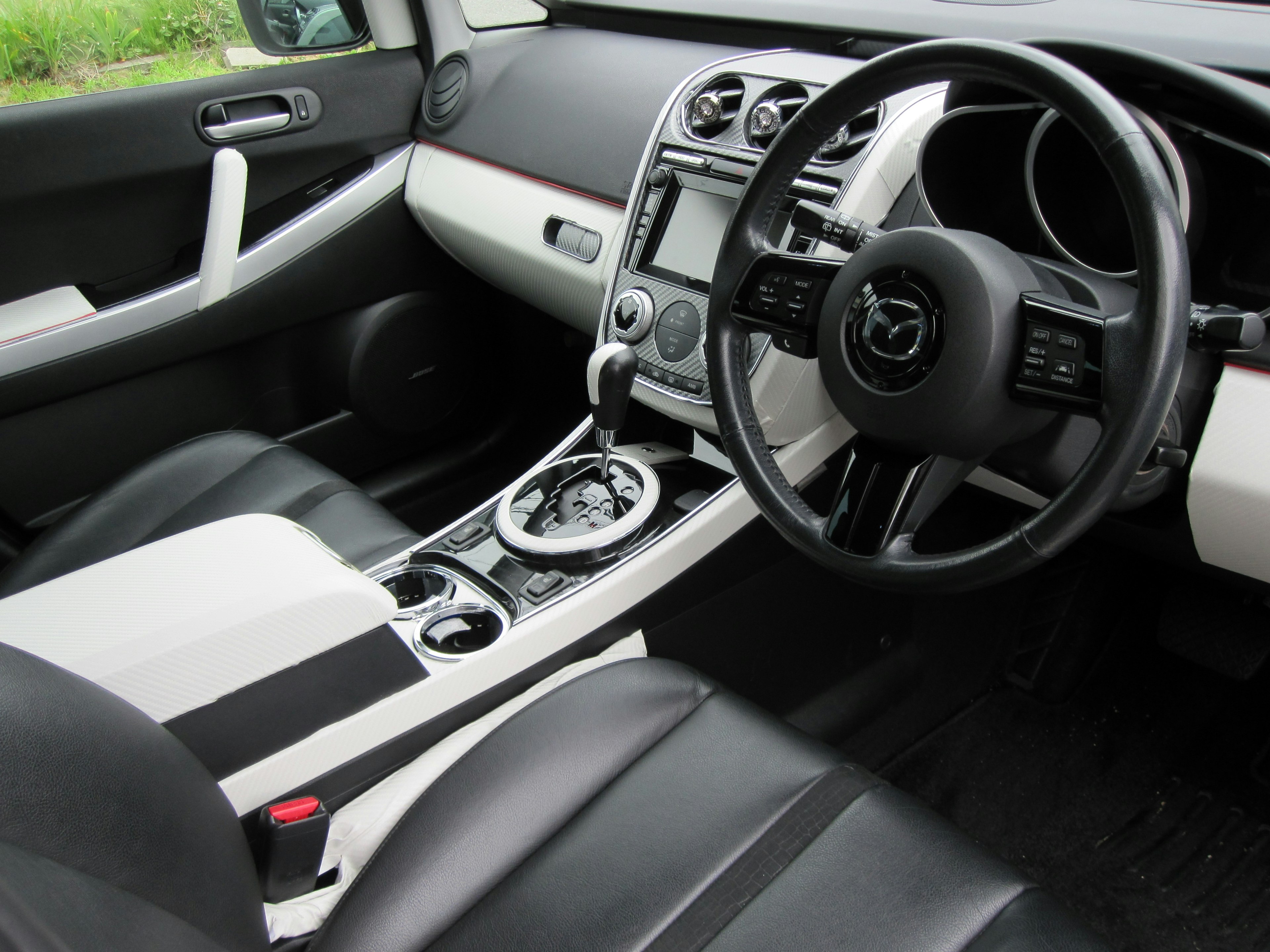 Intérieur d'une voiture avec des sièges en cuir noir et blanc console centrale et volant visibles