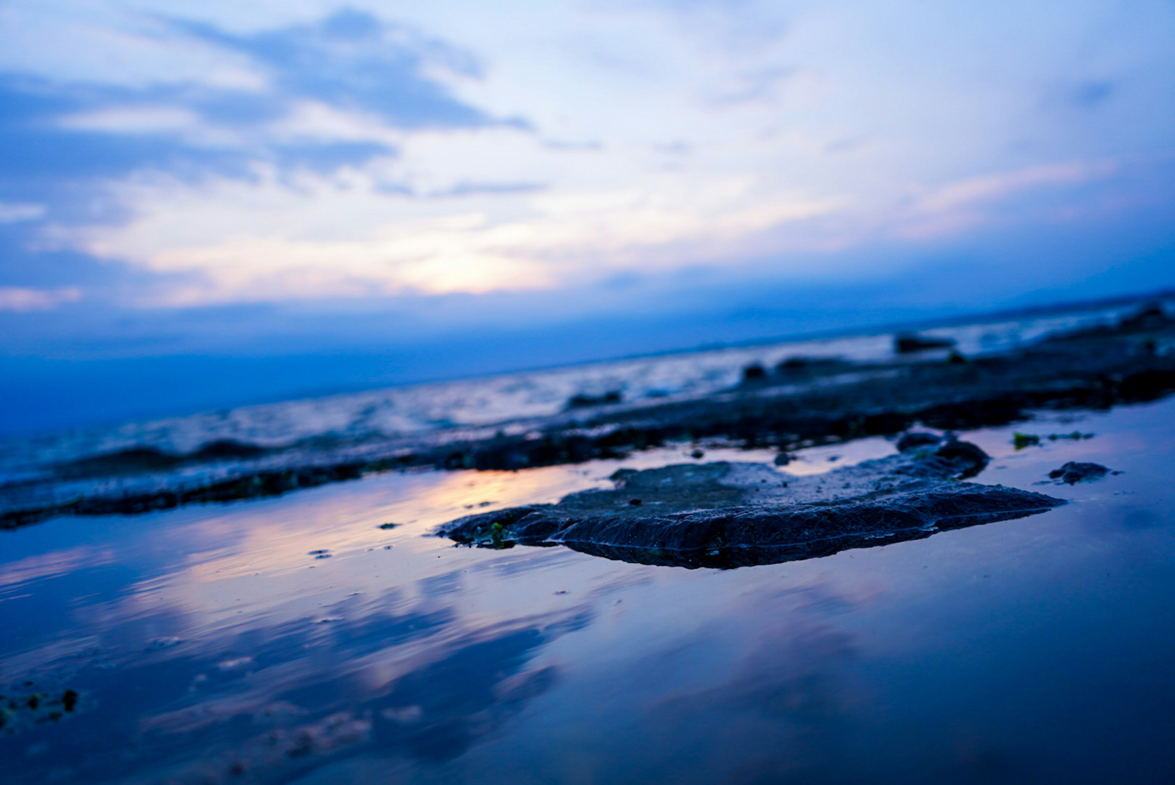 Scène de plage sereine avec des reflets de l'océan et du ciel bleus