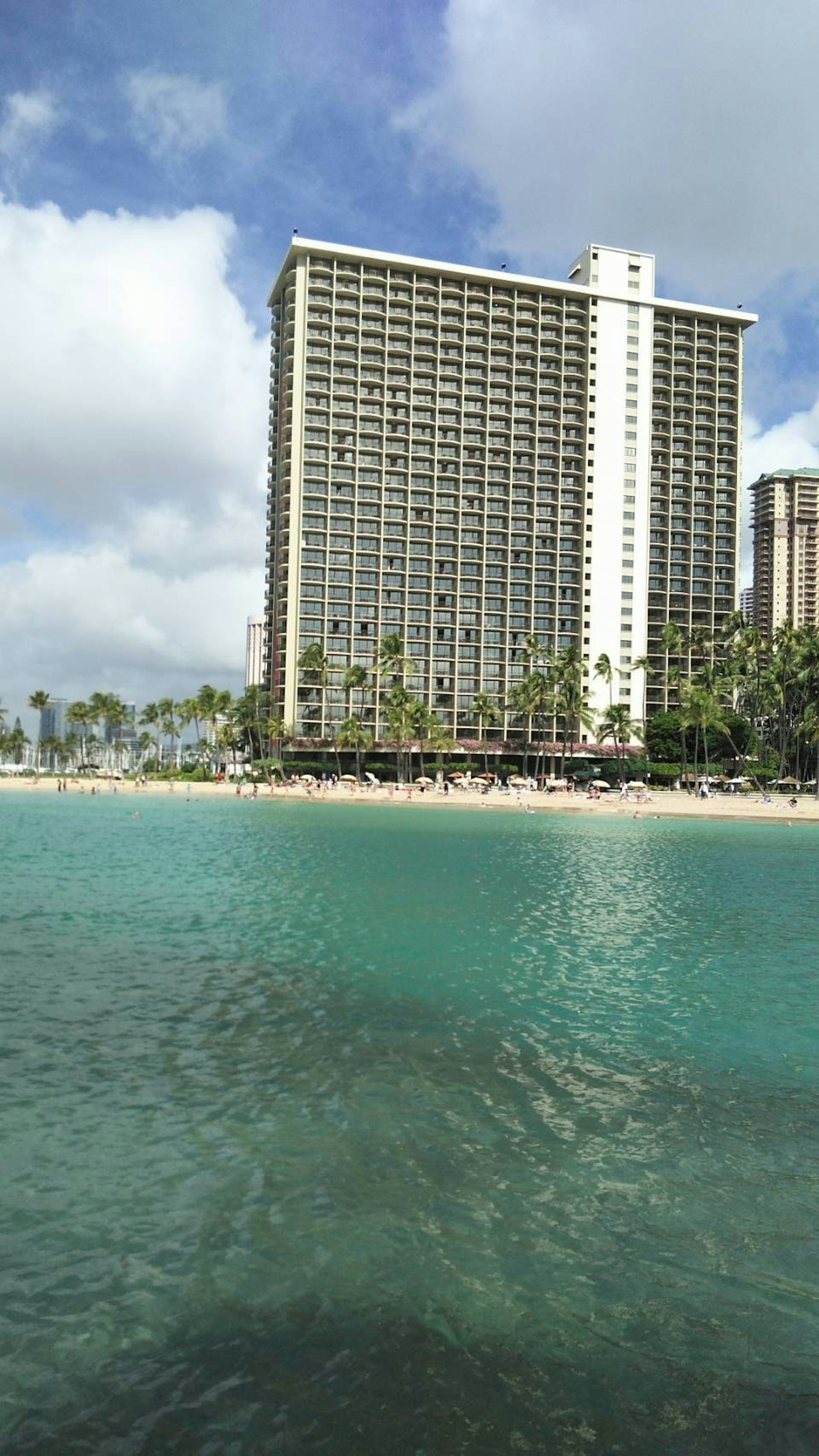 Paisaje hawaiano con un edificio alto junto al océano azul